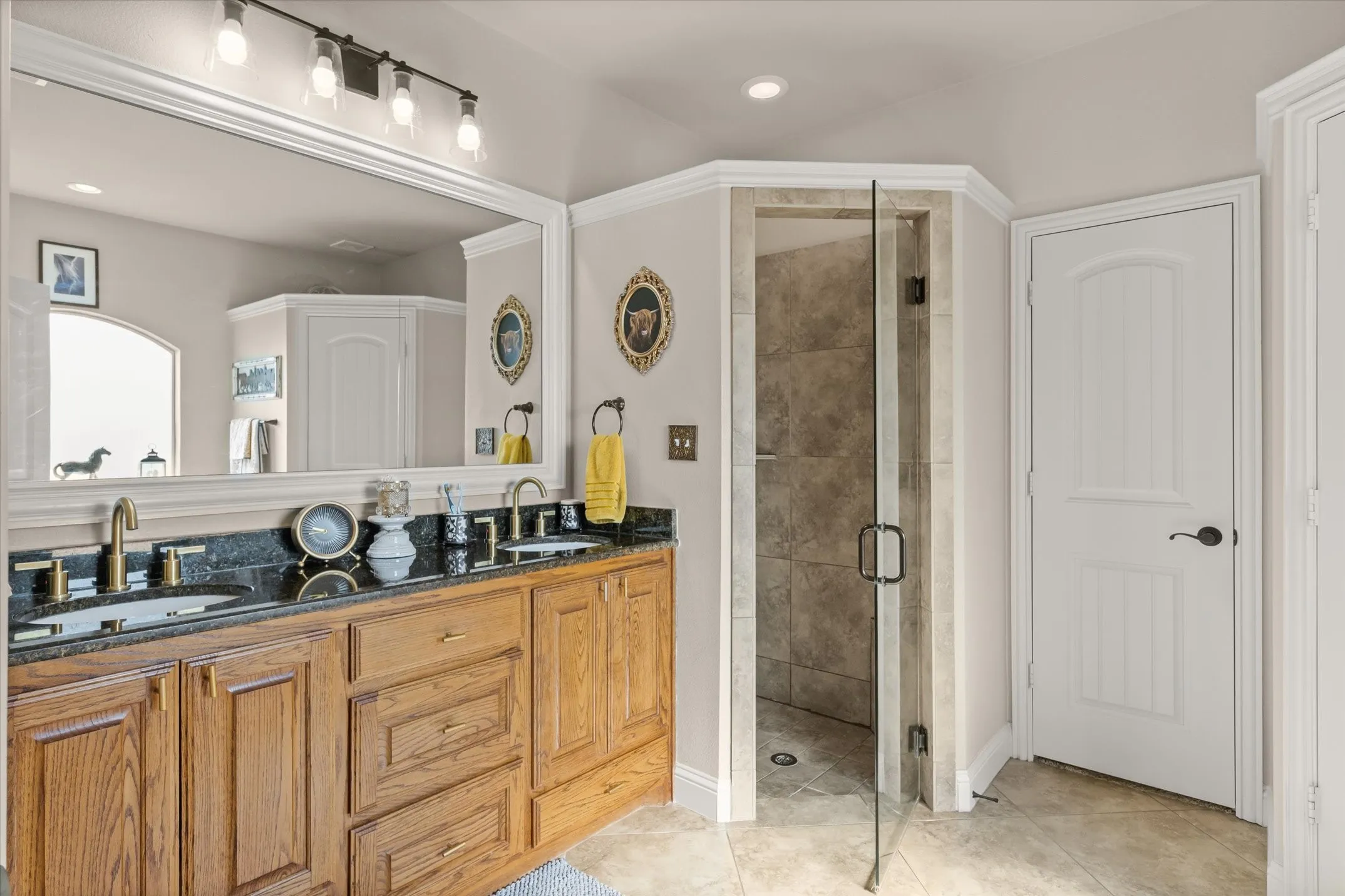 Double vanity with undermount sinks, stone countertop, and wood cabinetry