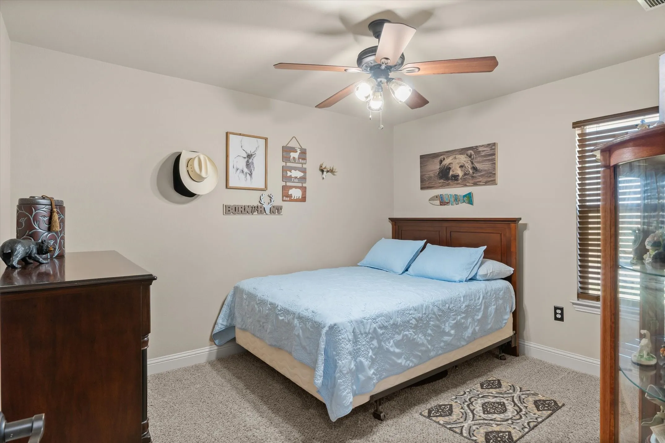 Carpeted flooring, ceiling fan with integrated lighting, window with blinds