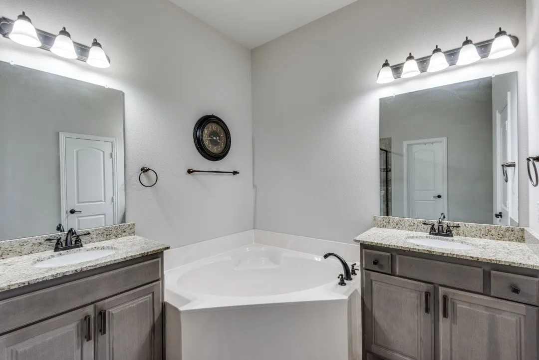 Dual vanities with granite countertops, undermount sinks, and bronze-finish fixtures