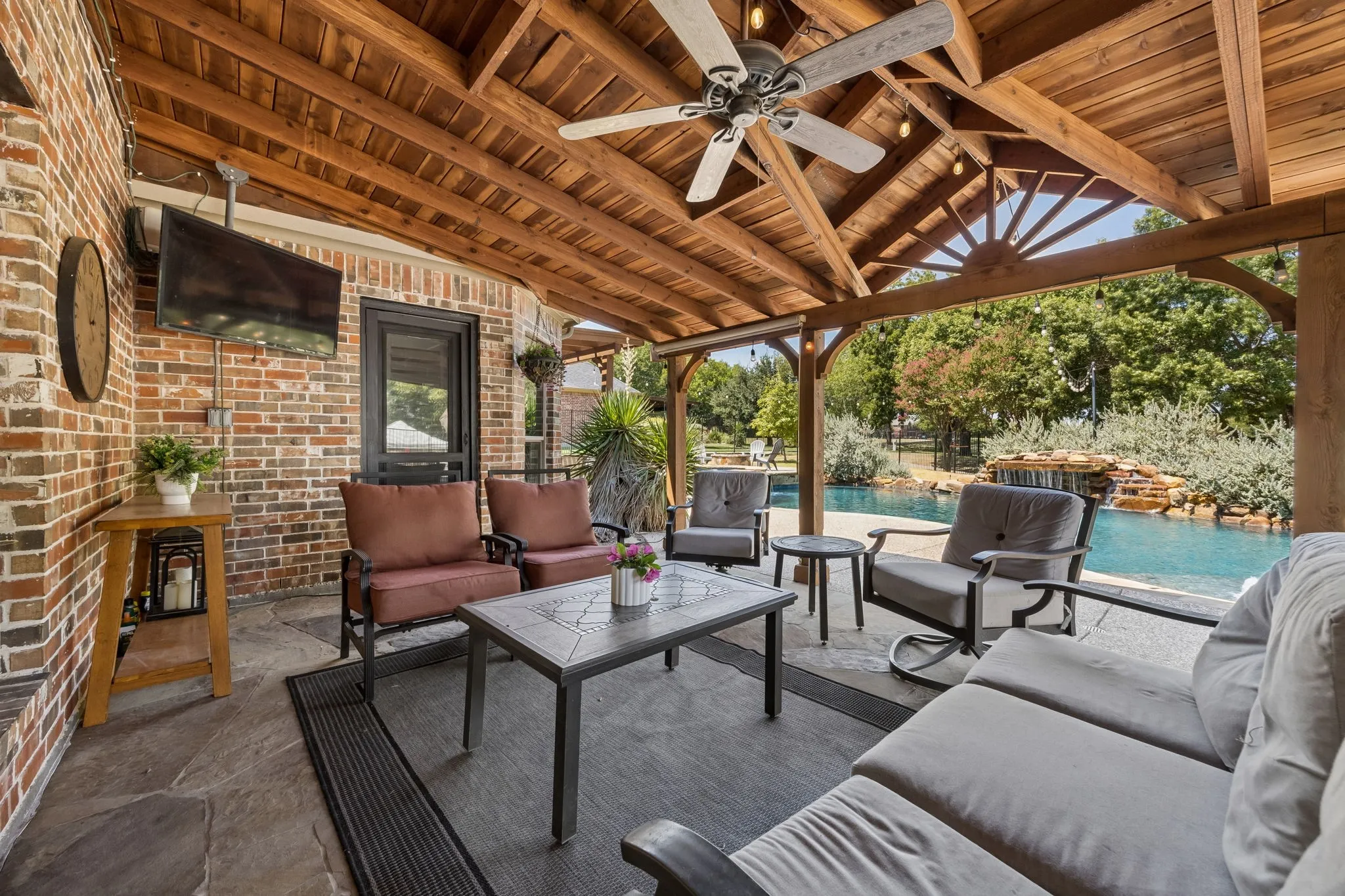 An Outdoor Living Room by the Pool - The expansive covered patio creates a true extension of the home, offering shade, room for multiple seating areas and an easy connection to the pool just steps away.