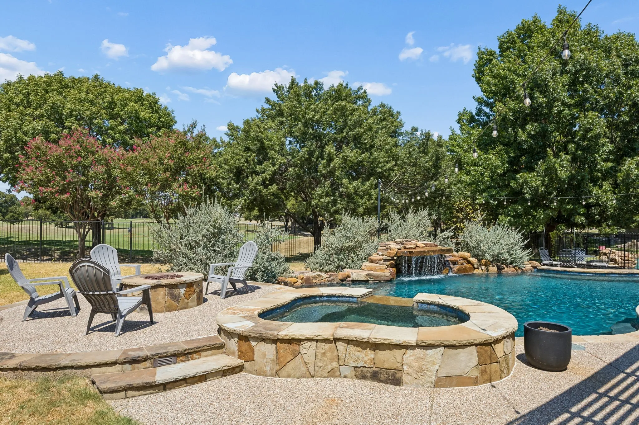 Pool, Spa and a Place to Gather - A raised spa, rock waterfall and separate fire pit area create distinct outdoor destinations, making the backyard just as inviting for cool evenings as it is for summer afternoons.
