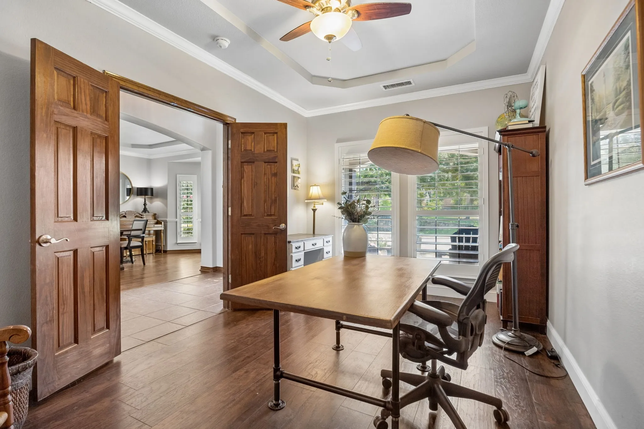 An Office with Architectural Character - Stained double doors, stained trim and natural light distinguish this dedicated study from the surrounding living areas while allowing it to feel connected to the main level when the doors are open.