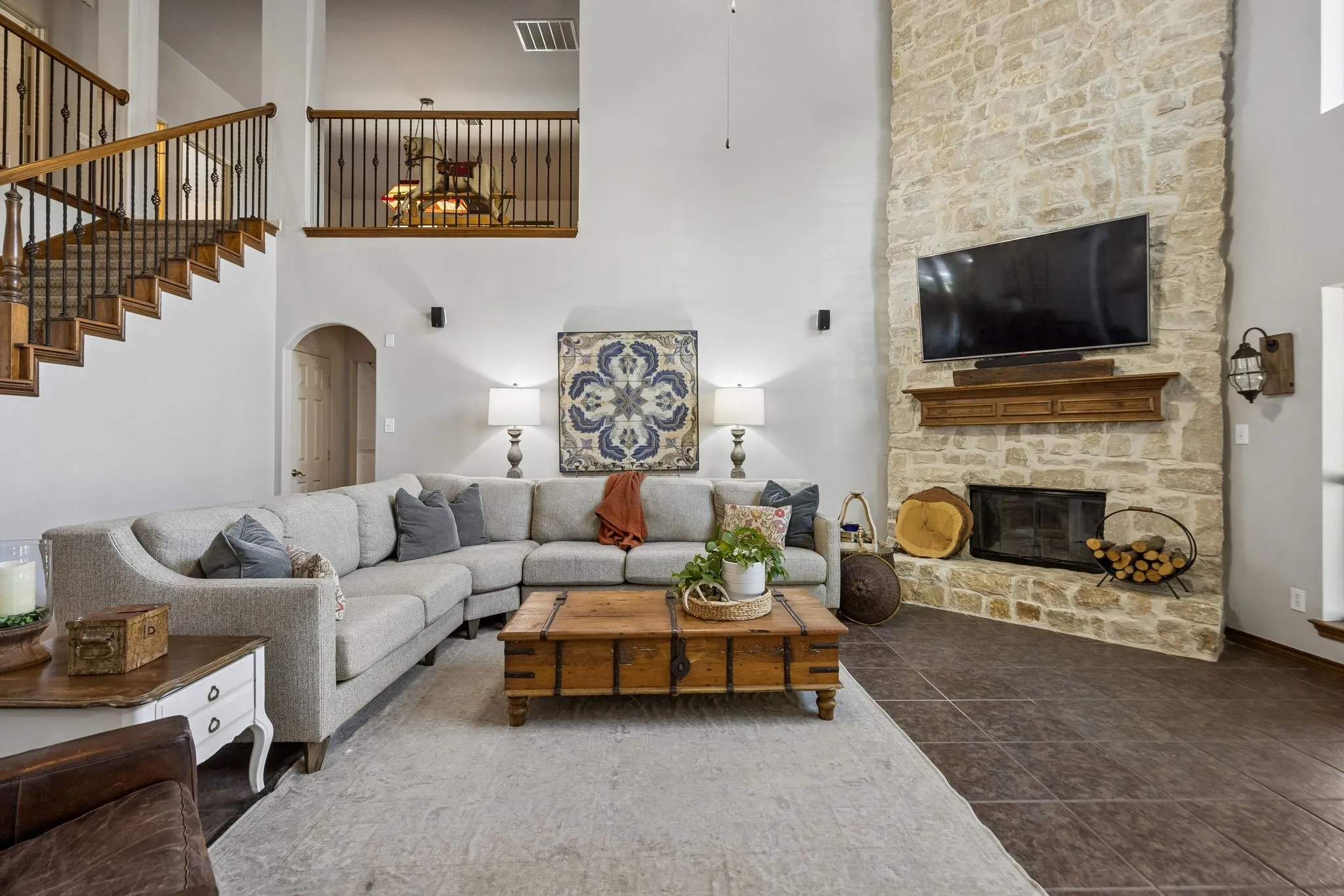 A Family Room That Lives Large - Soaring two-story ceilings, generous proportions and tall windows create an open, airy gathering space with plenty of room for everyday living and entertaining, while the floor-to-ceiling stone fireplace gives the room a strong architectural focal point.