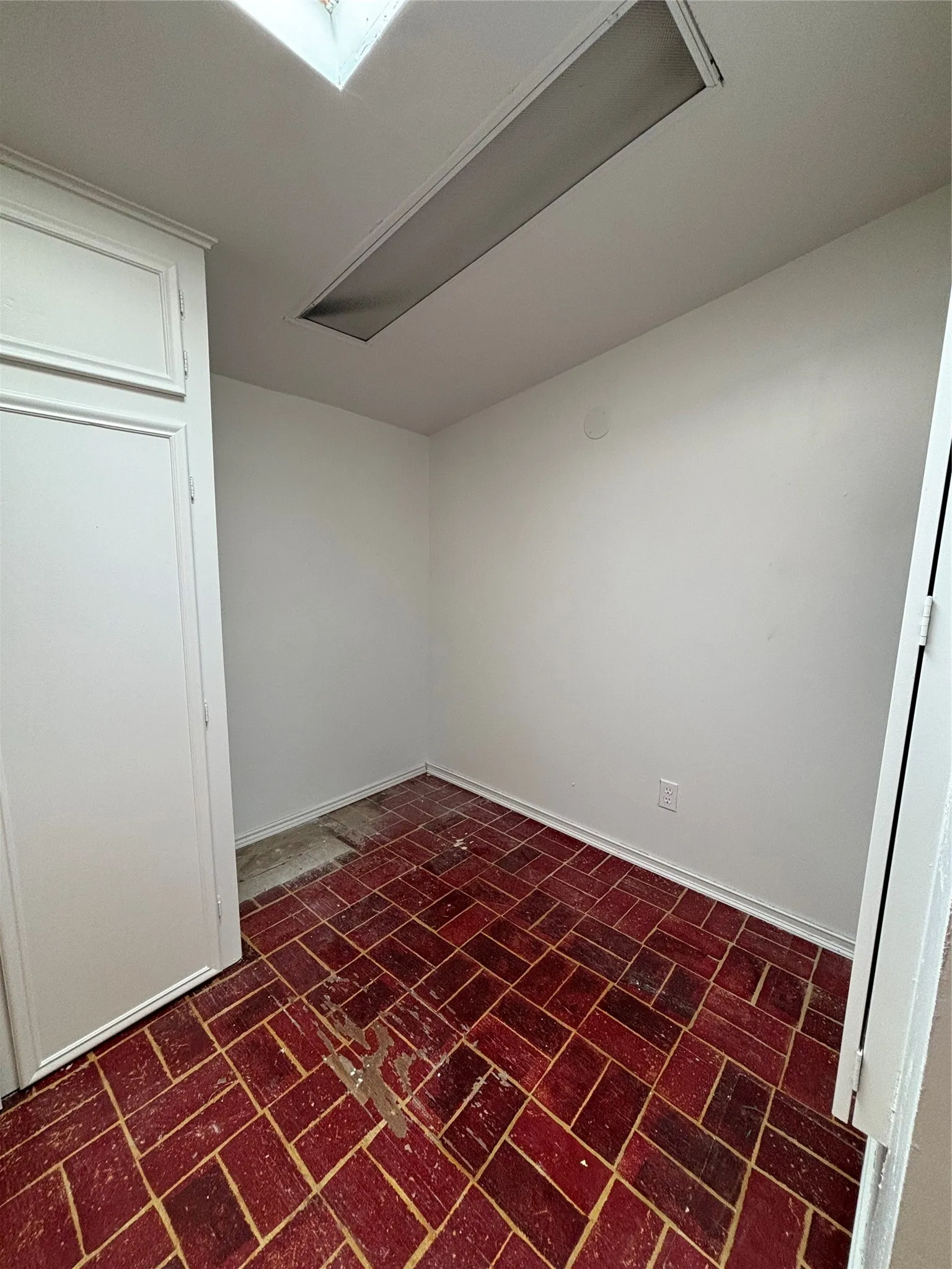 Unfurnished room with brick patterned floors and cooling unit
