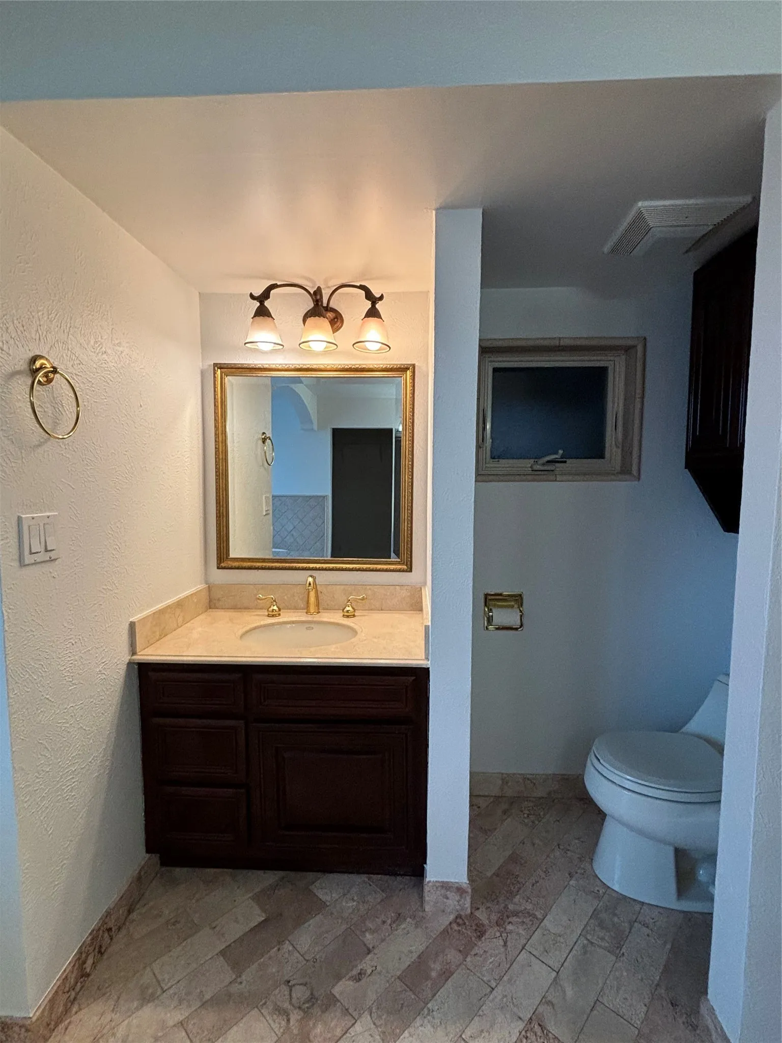 Bathroom featuring vanity and a textured wall