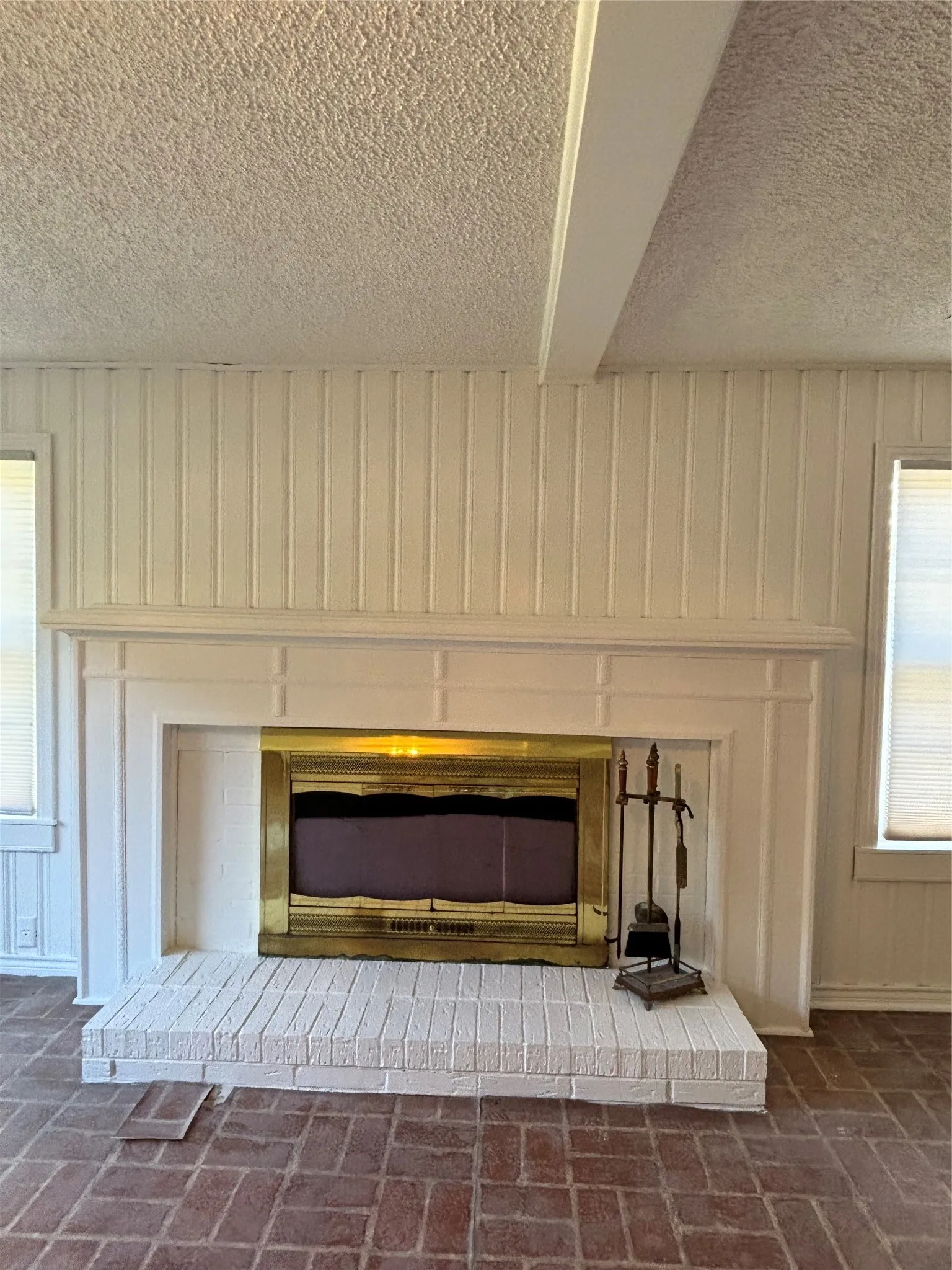 Detailed view of a brick fireplace and a textured ceiling