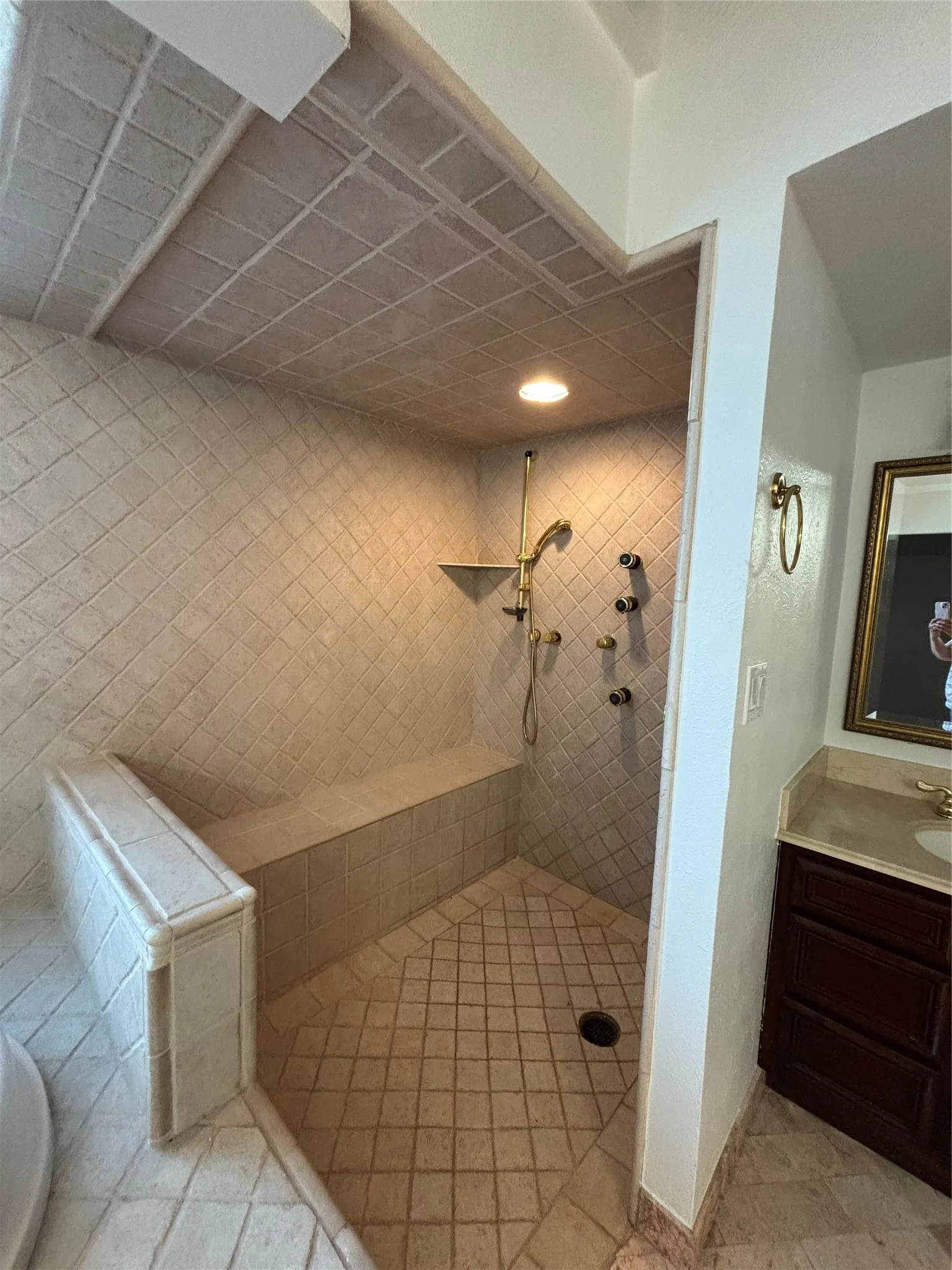 Bathroom with tiled shower and vanity