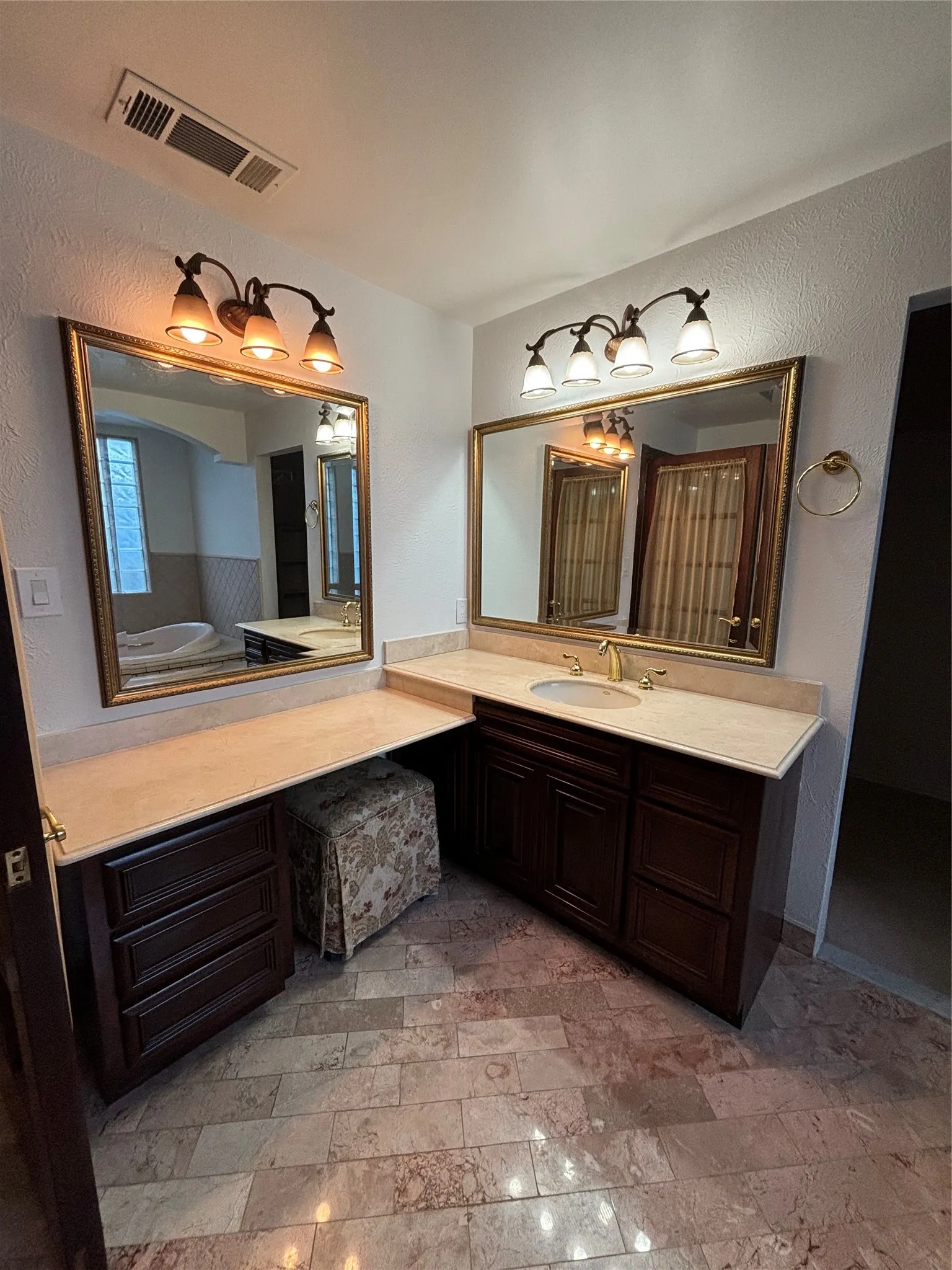 Full bathroom featuring a textured wall, a tub to relax in, vanity, and light stone finish flooring