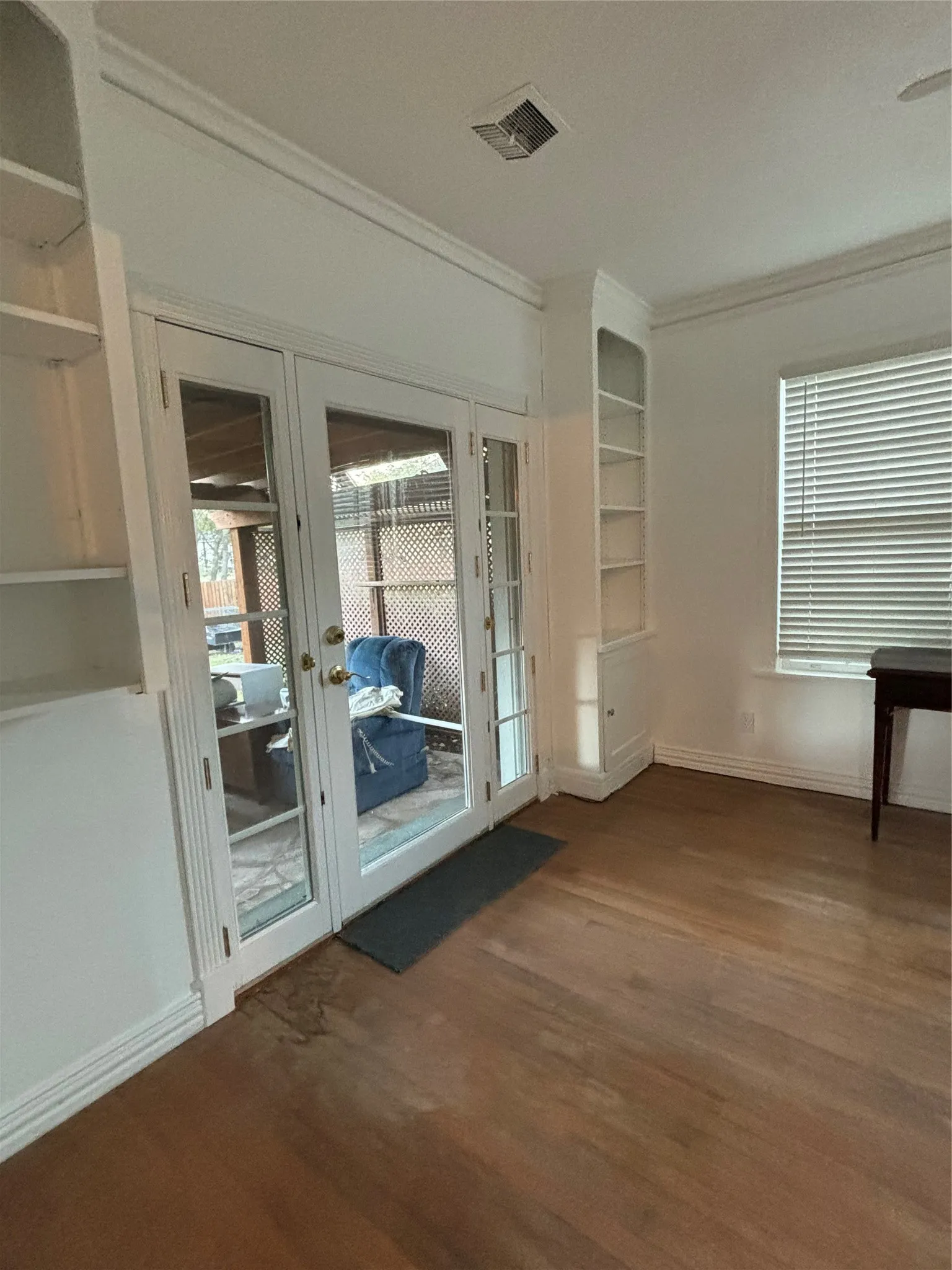 Doorway featuring ornamental molding, wood finished floors, and french doors