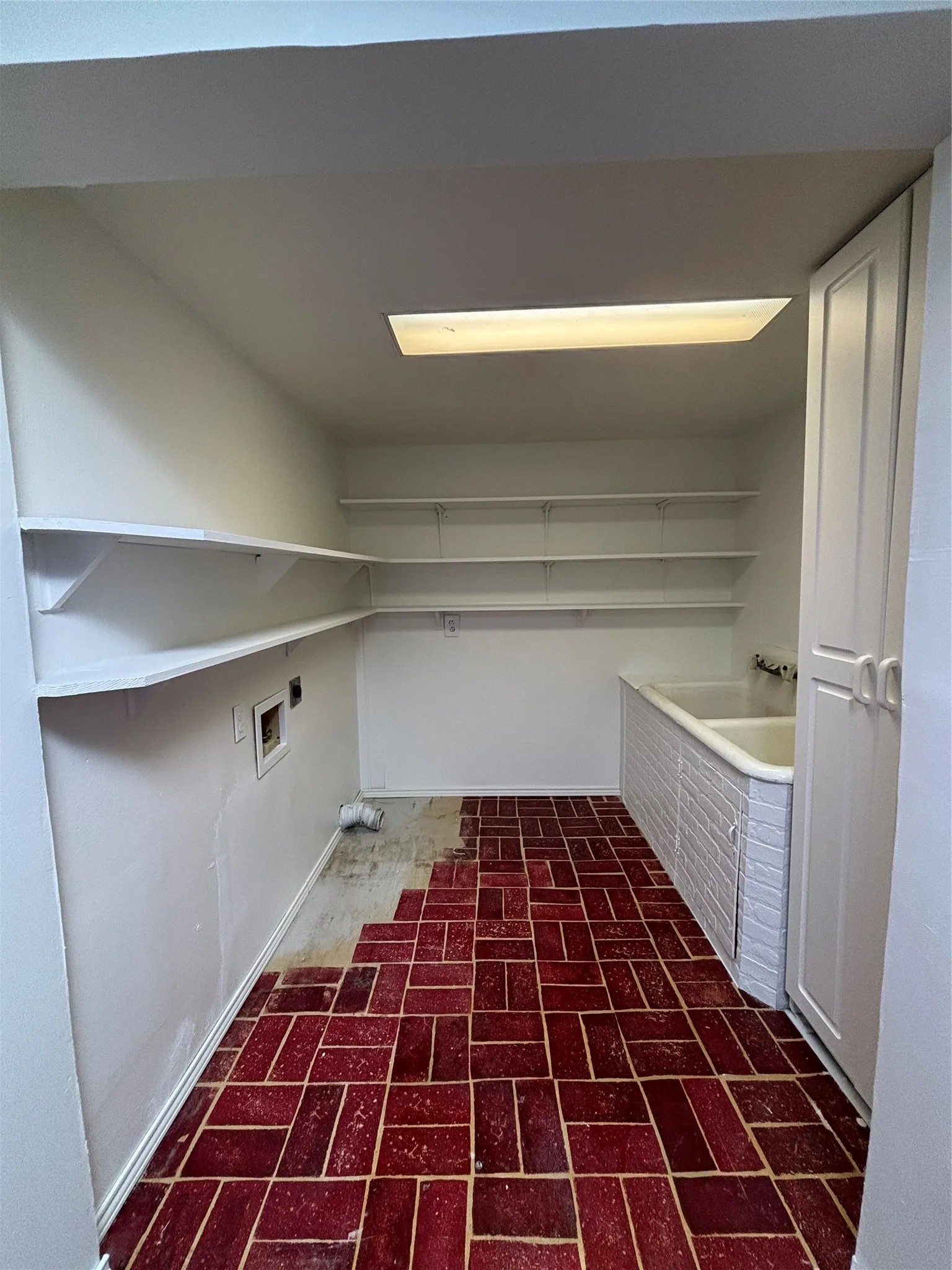 Laundry room with brick patterned flooring, hookup for a washing machine, and electric dryer hookup