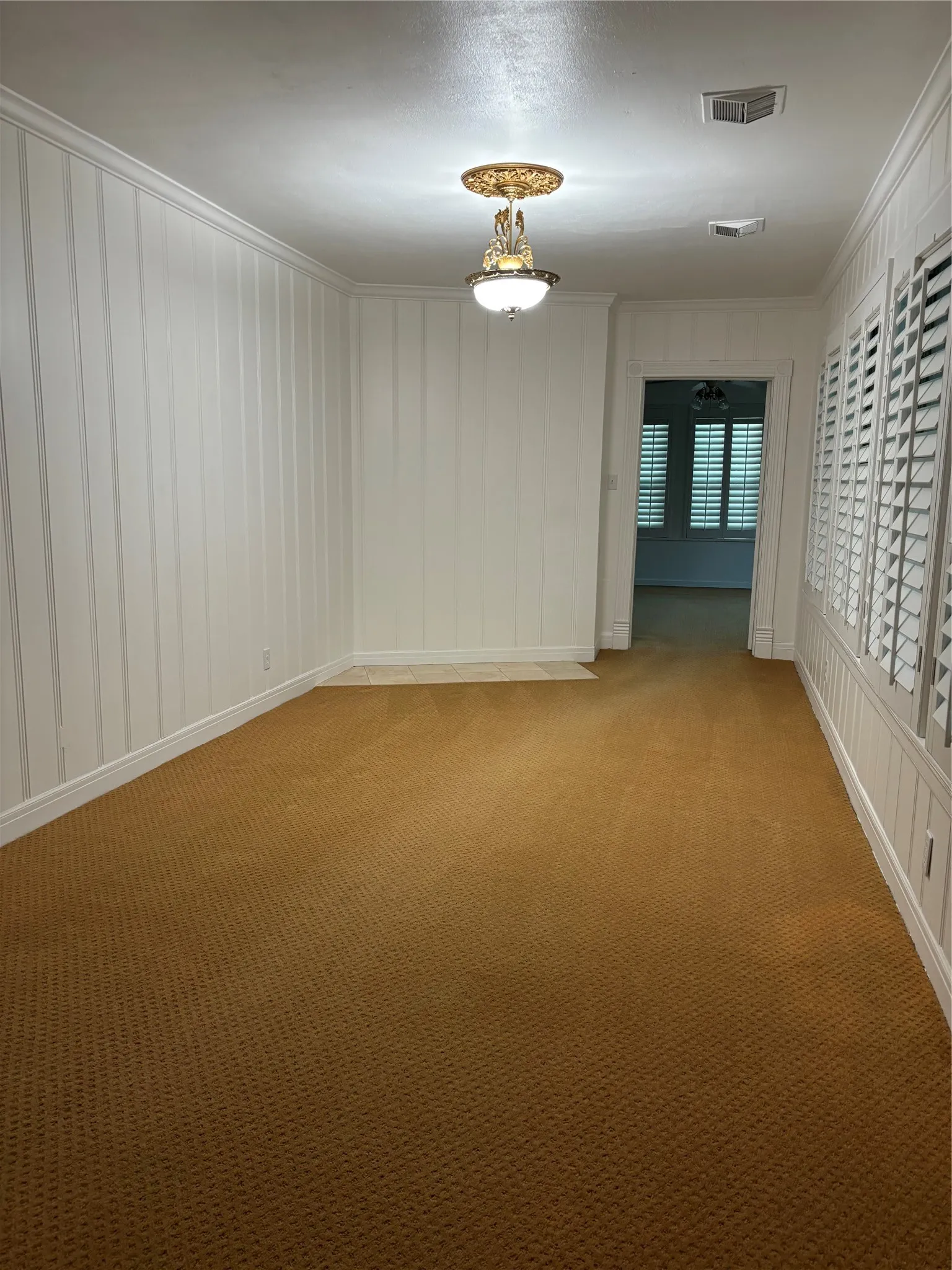Empty room with carpet and ornamental molding