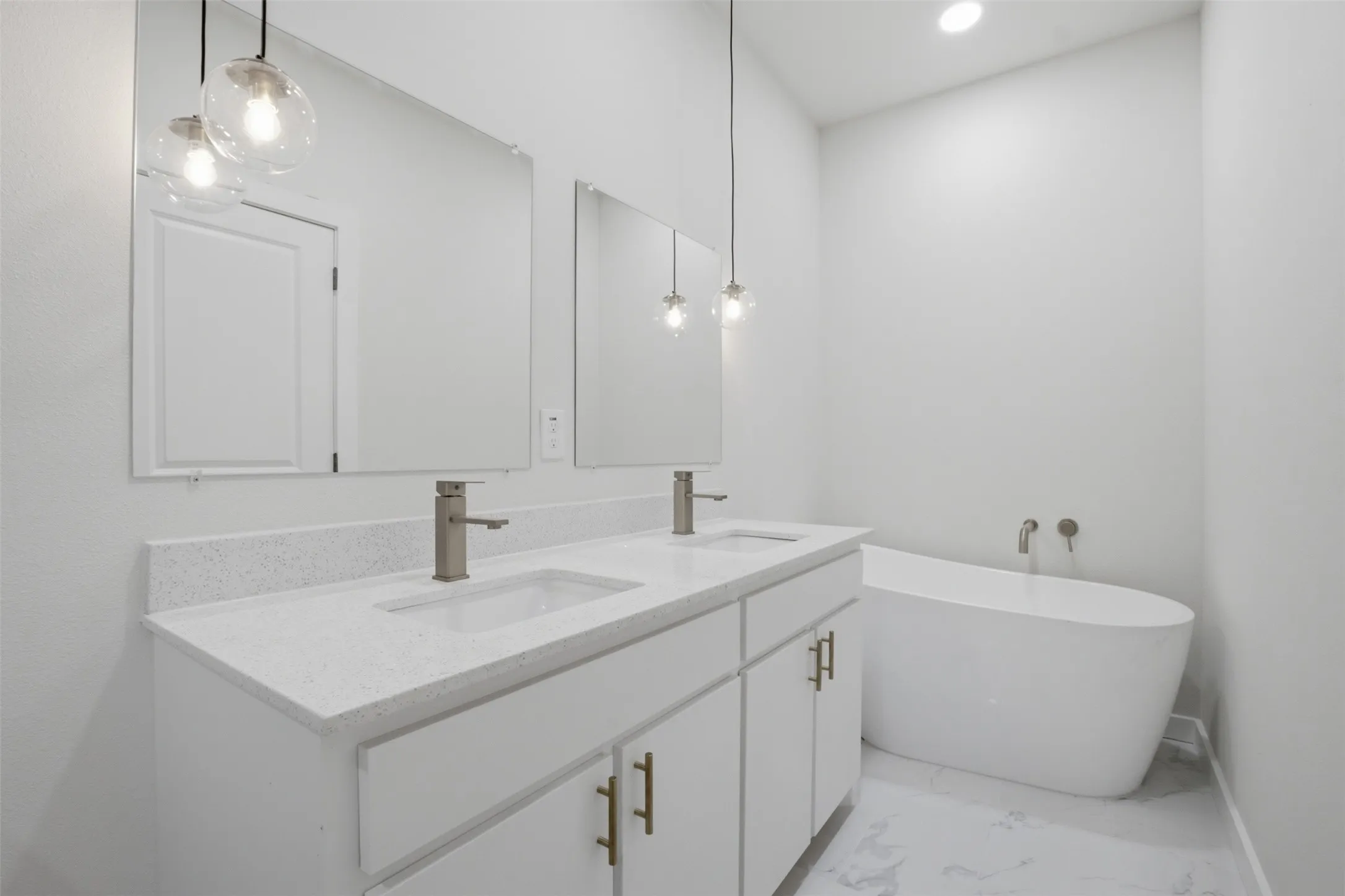 Dual vanities with white cabinetry, quartz countertops, and brushed nickel fixtures
