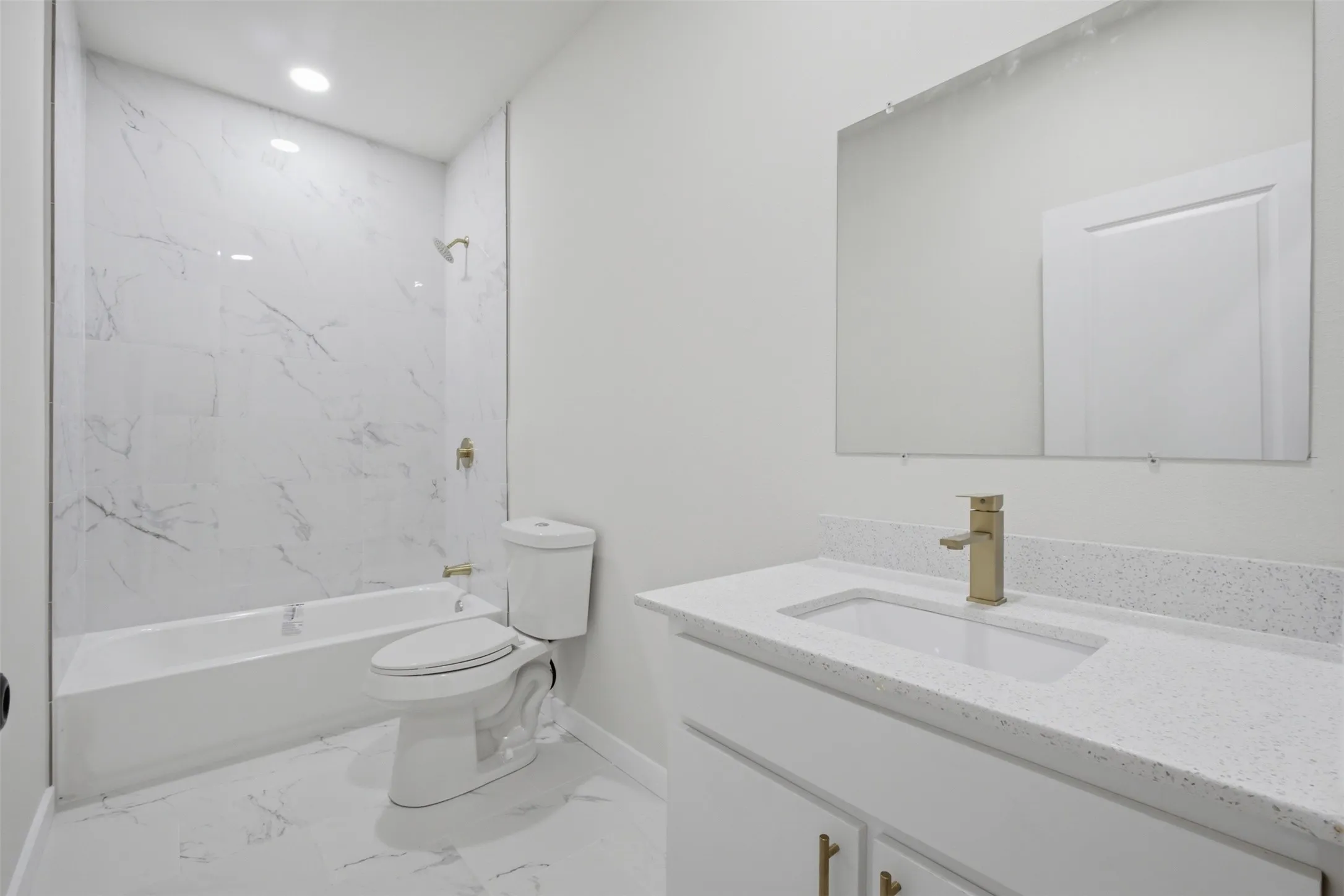 White vanity with a speckled countertop and an undermount sink