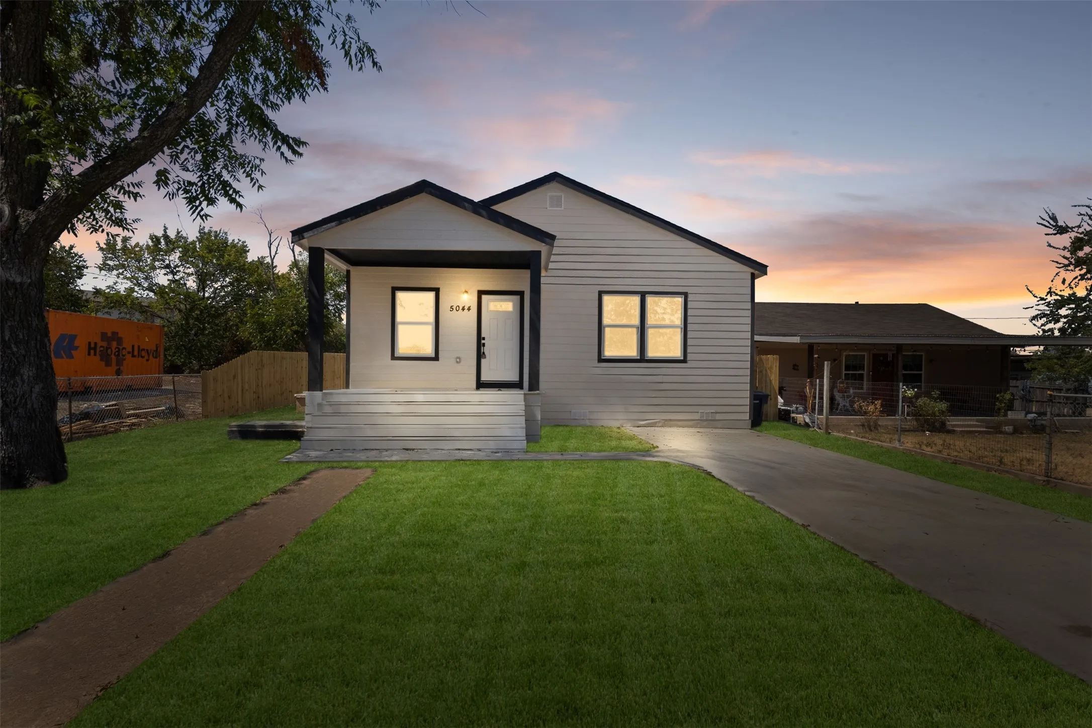 Single-story residence featuring light-colored siding, a covered front porch, and a dark-toned roof