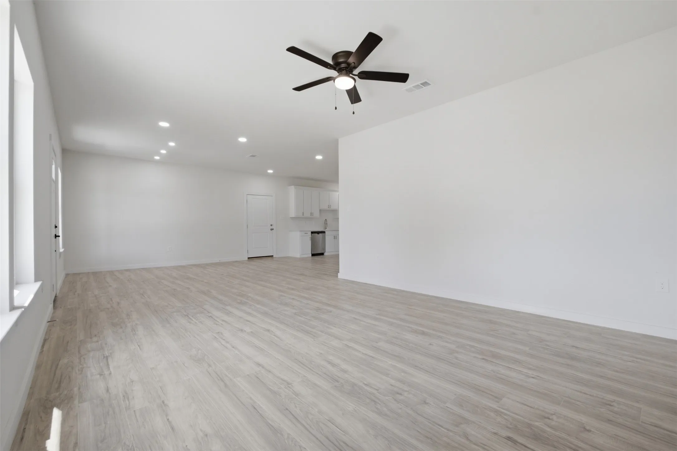 Wood-finish flooring, recessed lighting, and a ceiling fan