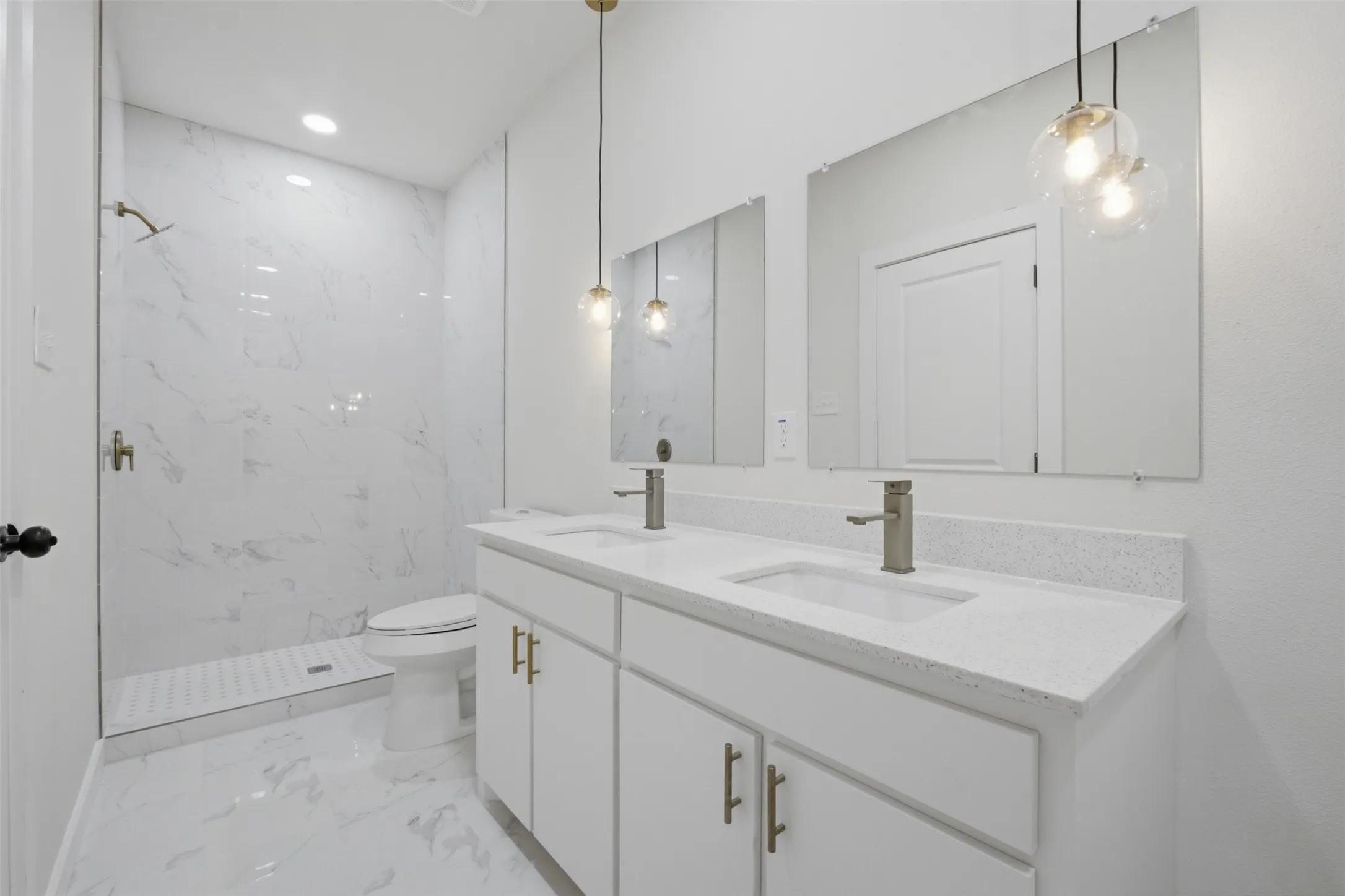 Dual vanity with light-toned countertops, contemporary pendant lighting, undermount sinks, and brushed nickel faucets