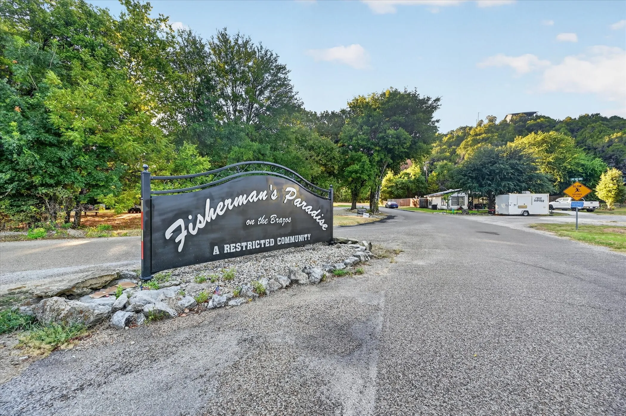 Community entrance sign featuring decorative ironwork and stone detailing