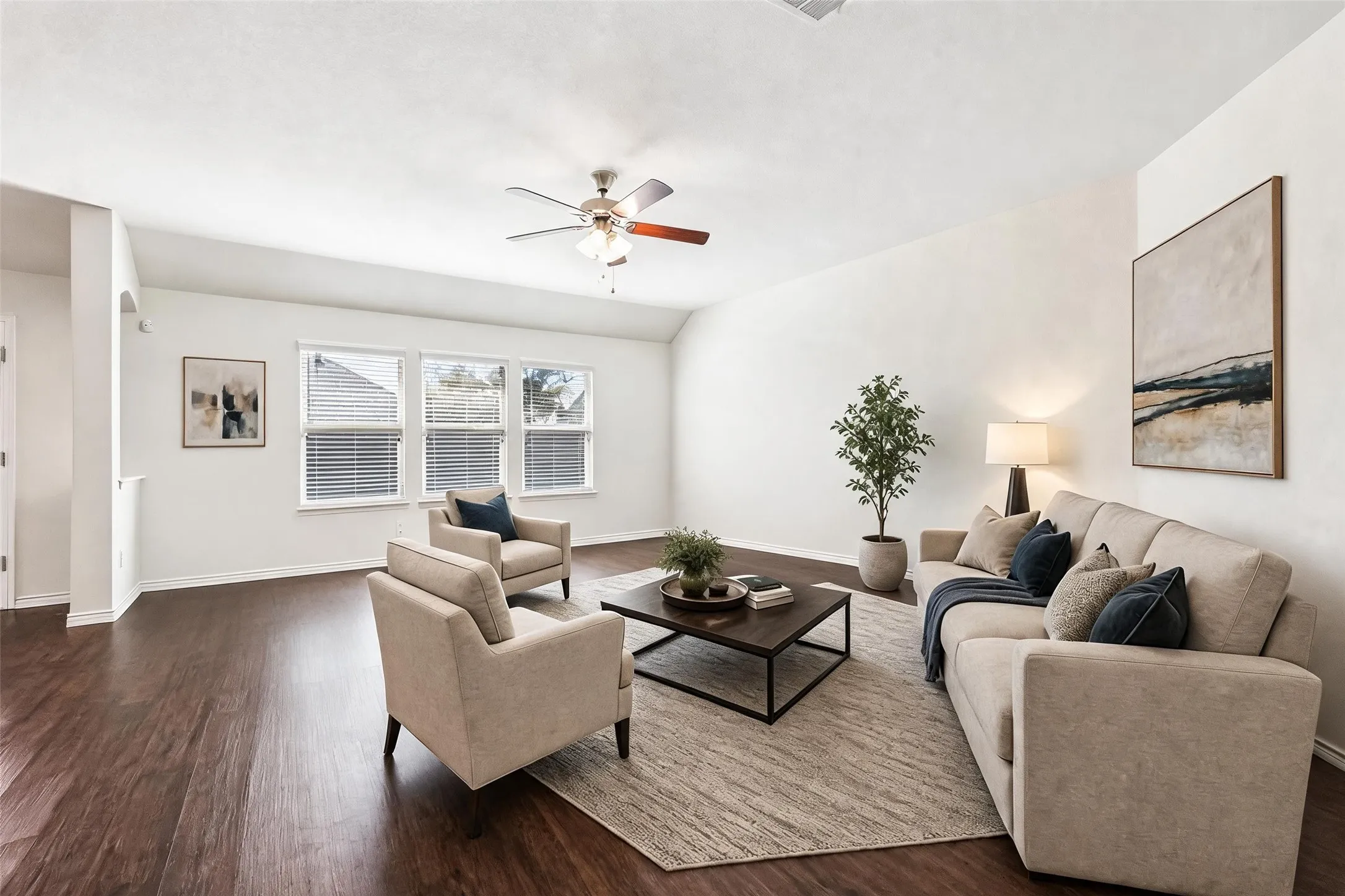 Expansive living area featuring wood-finish flooring, multiple windows with blinds, a ceiling fan, and recessed lighting, virtually staged