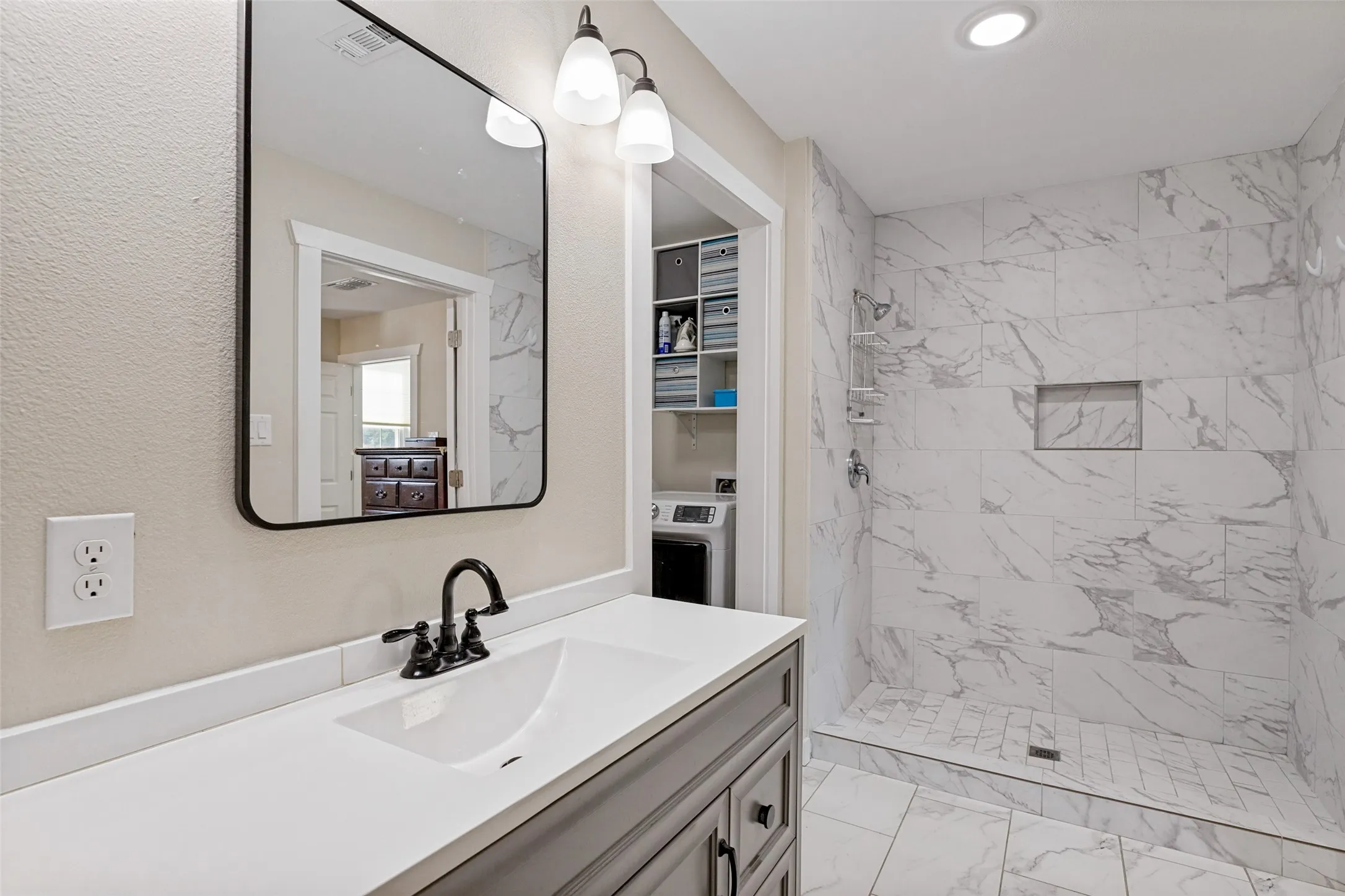 Primary bathroom, shower and views the laundry room
