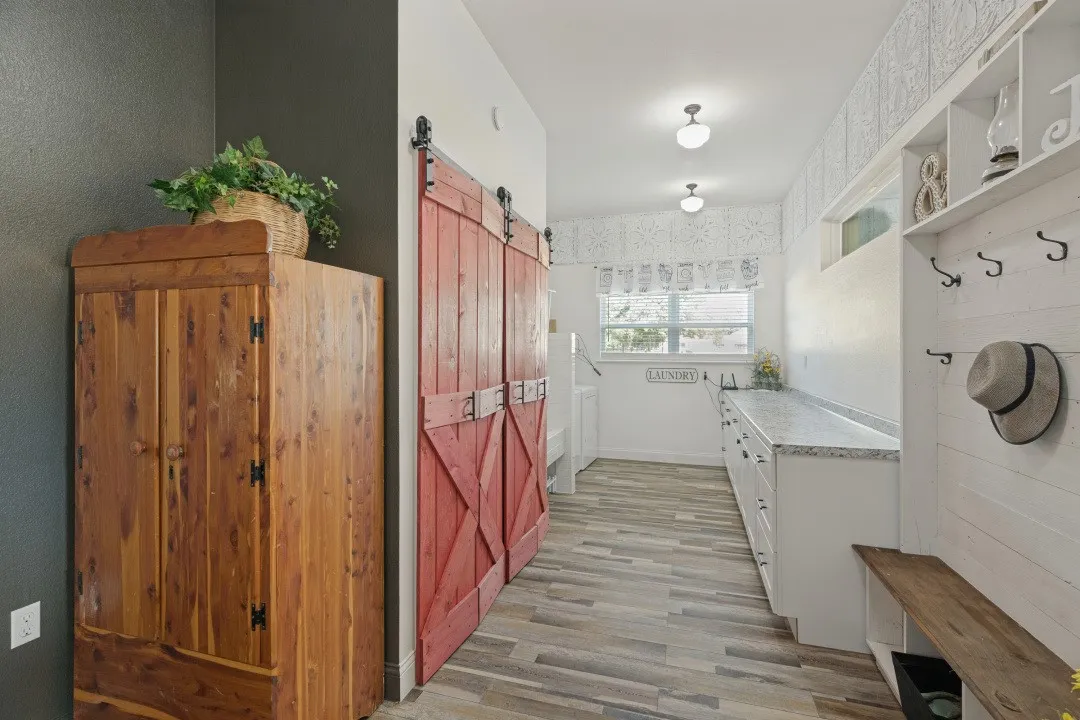 Massive Laundry room with lots of counter top space and storage behind barndoor