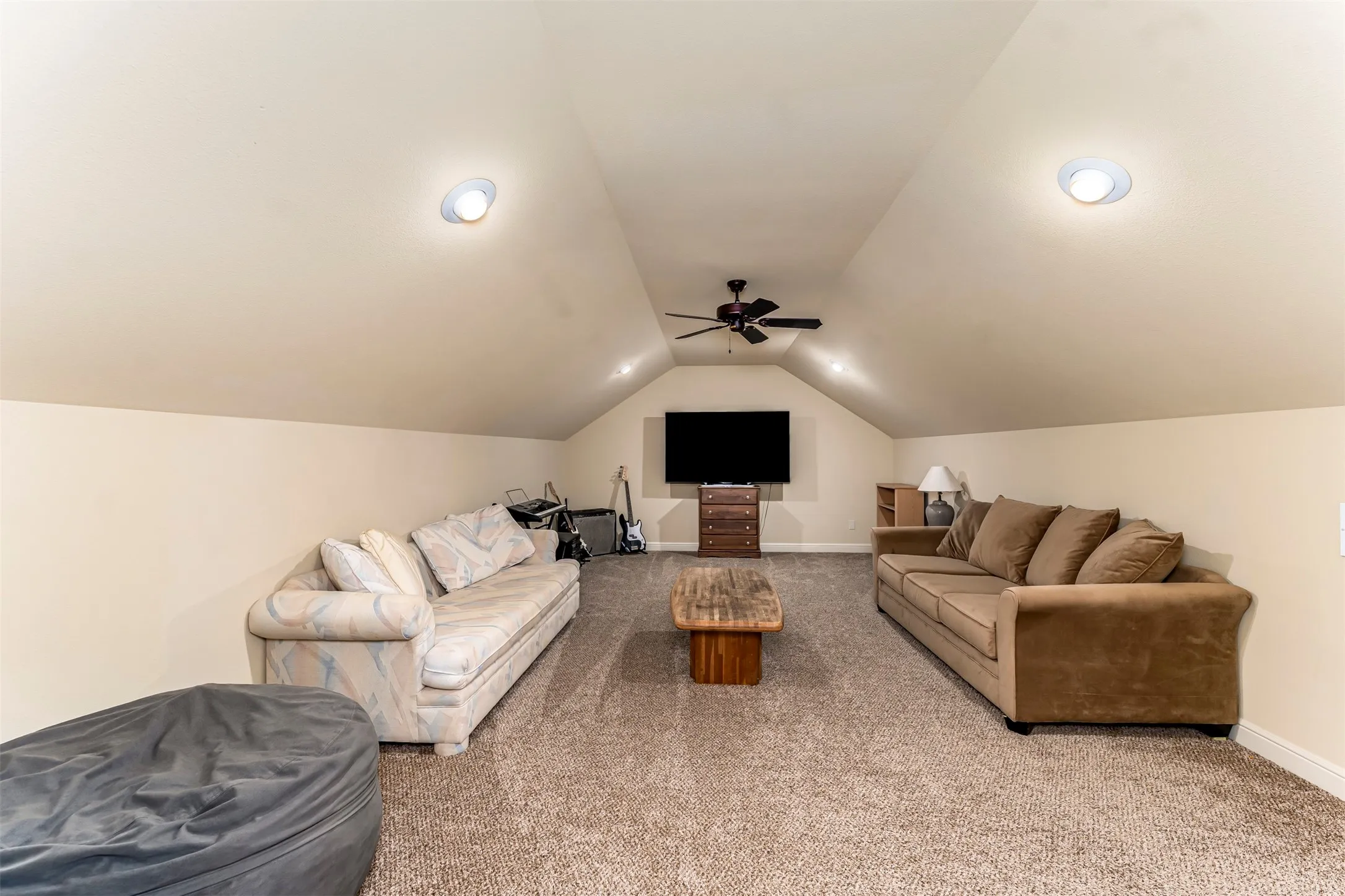 Carpeted bonus room featuring a vaulted ceiling with recessed lighting and a ceiling fan