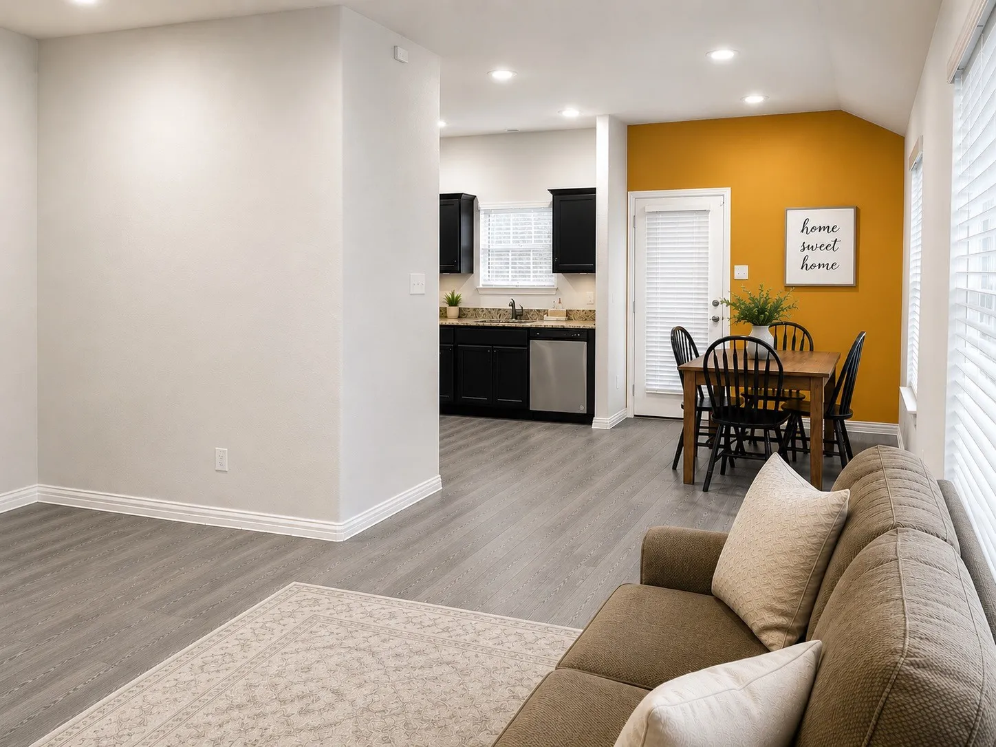 Recessed lighting, wood-finish flooring, white window blinds, dark cabinetry, and stainless steel appliances