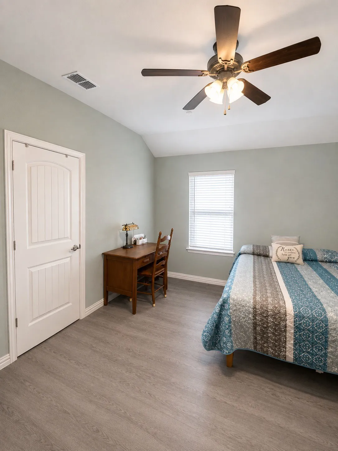 Wood-finish flooring, a ceiling fan with integrated lighting, a paneled interior door, and a window with horizontal blinds