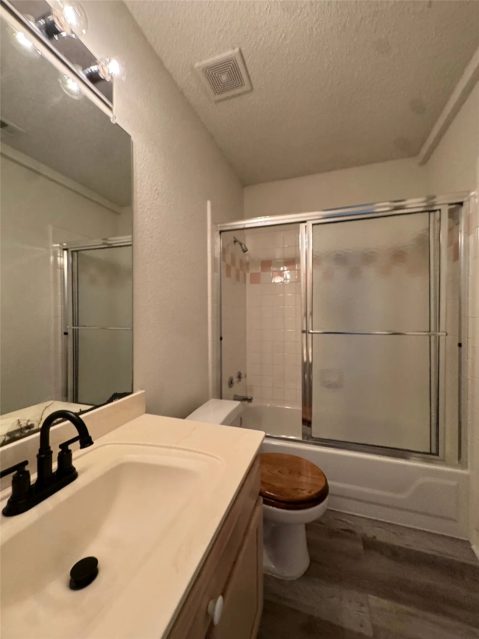 Vanity with integrated sink, black-finish faucet, and wood-finish cabinetry