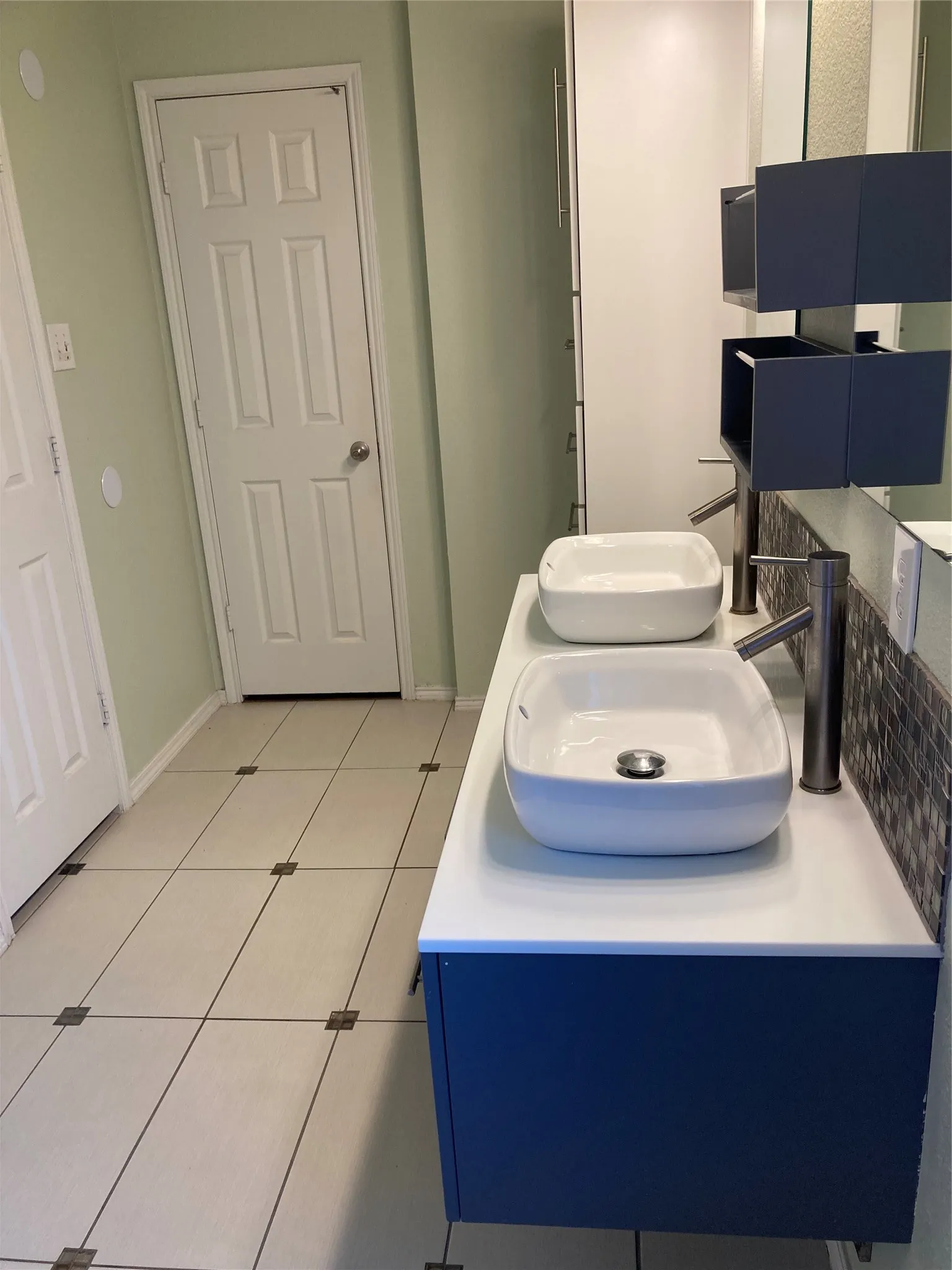Primary bathroom features double sinks and extra cabinets for storage.