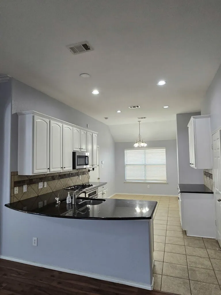 Breakfast area is located by the windows in the kitchen.