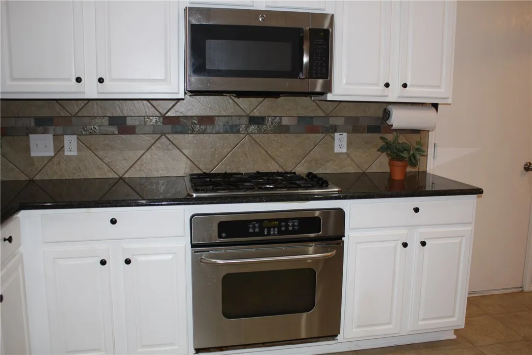 Kitchen features granite counter tops and stainless steel built in appliances.  Door to the right leads to the garage.