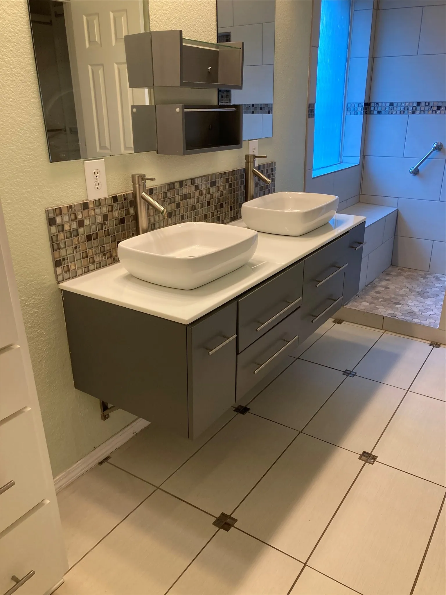 Features include double sinks and a walk-in shower with a seat.