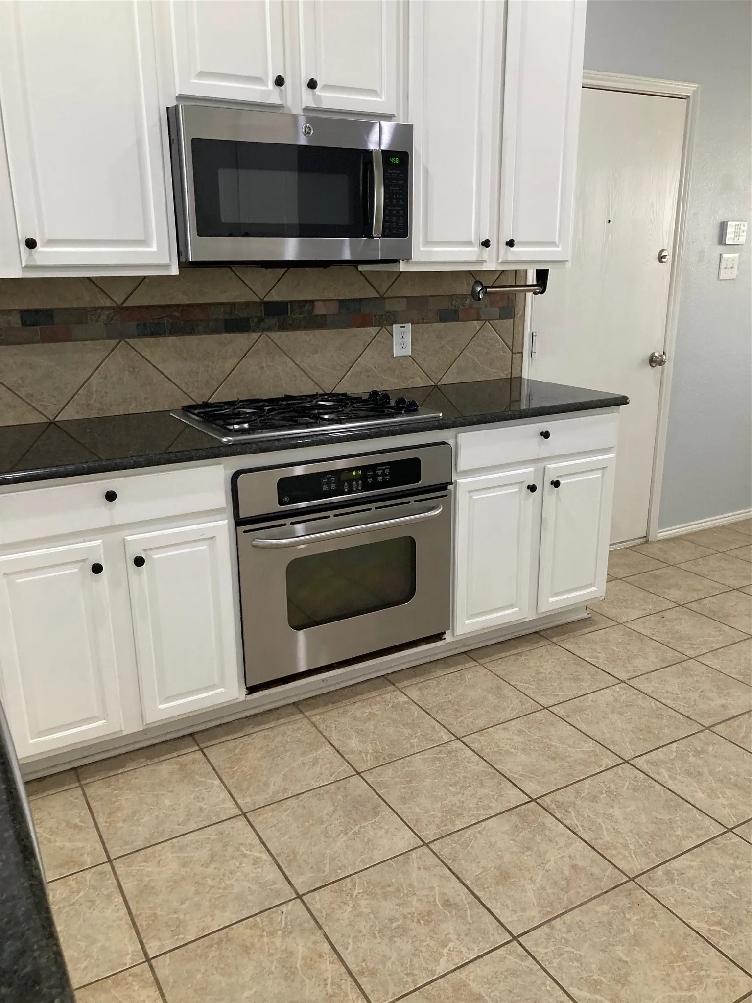 Gas cooktop and granite counters are features of the kitchen.
