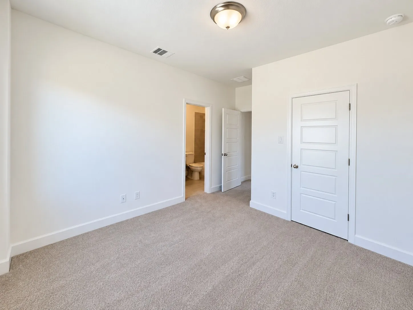 Neutral-toned carpeting, white walls, and a contemporary five-panel interior door