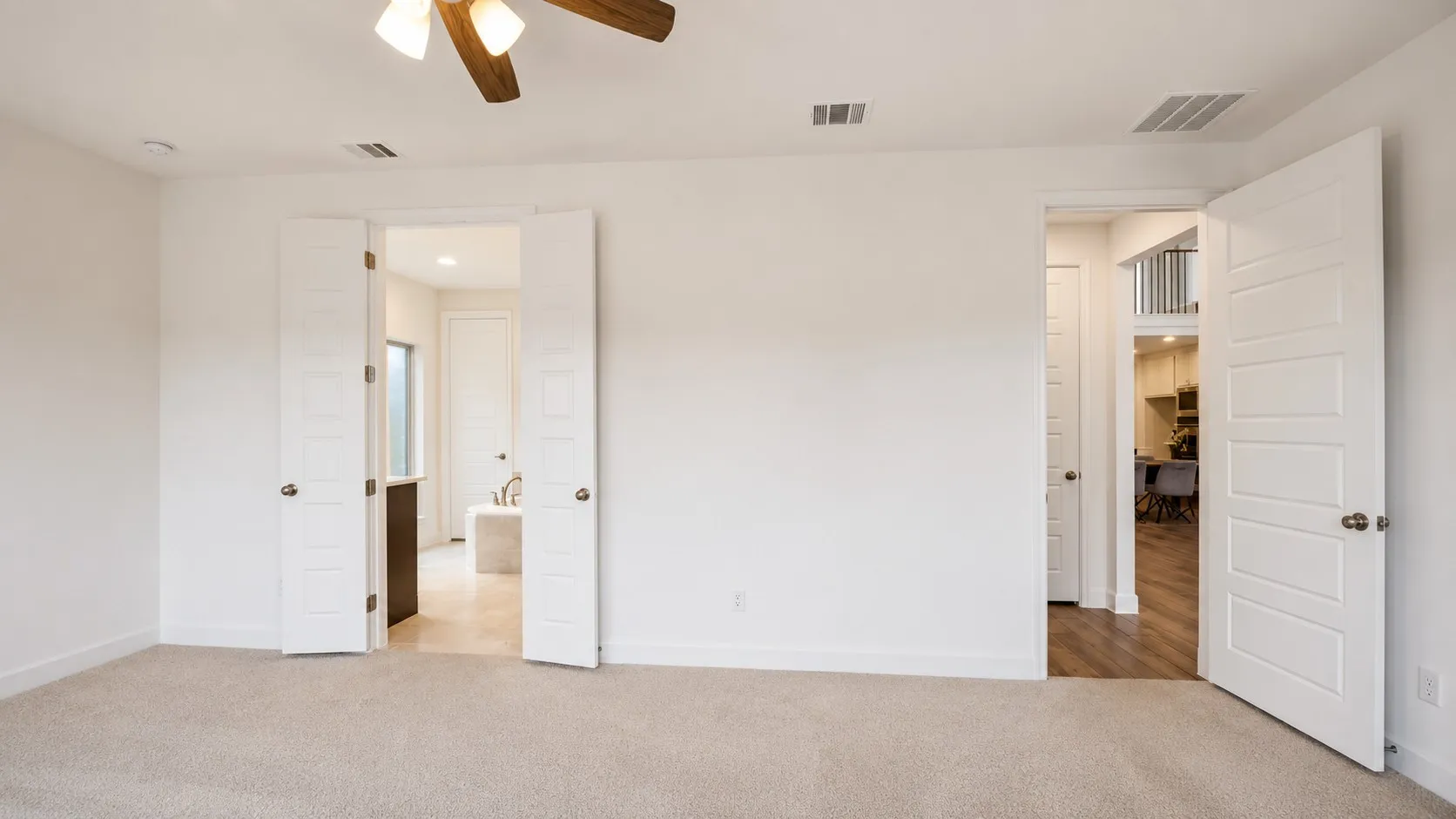 Recessed lighting, ceiling fan with wood-finish blades, and neutral carpeting