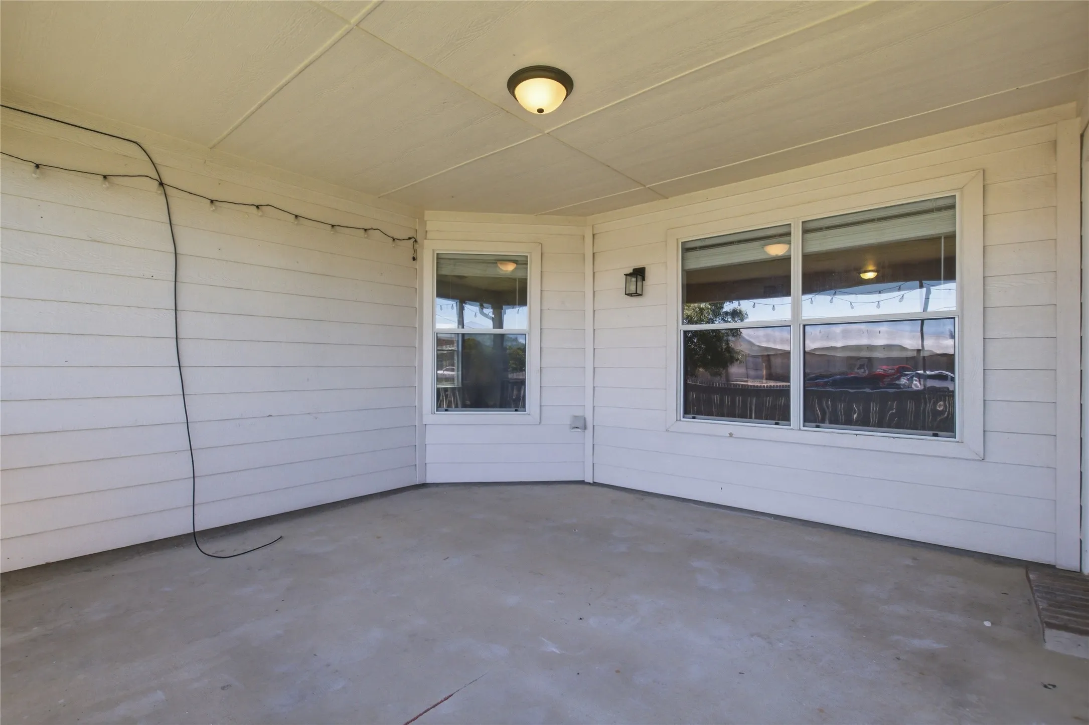 Covered patio with a concrete surface, white paneled siding, and recessed lighting