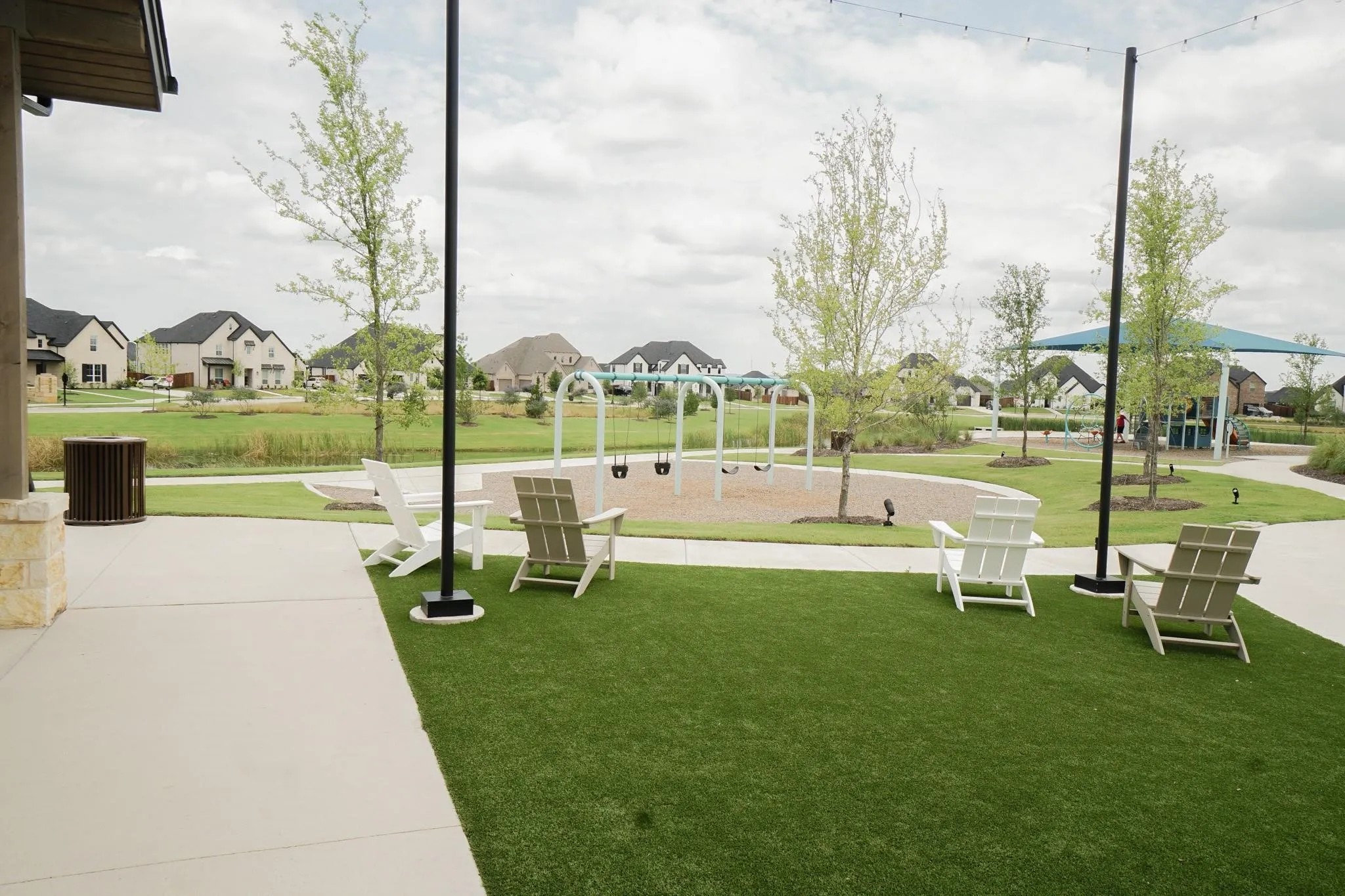 Community green space featuring a playground, paved pathways, and mature landscaping