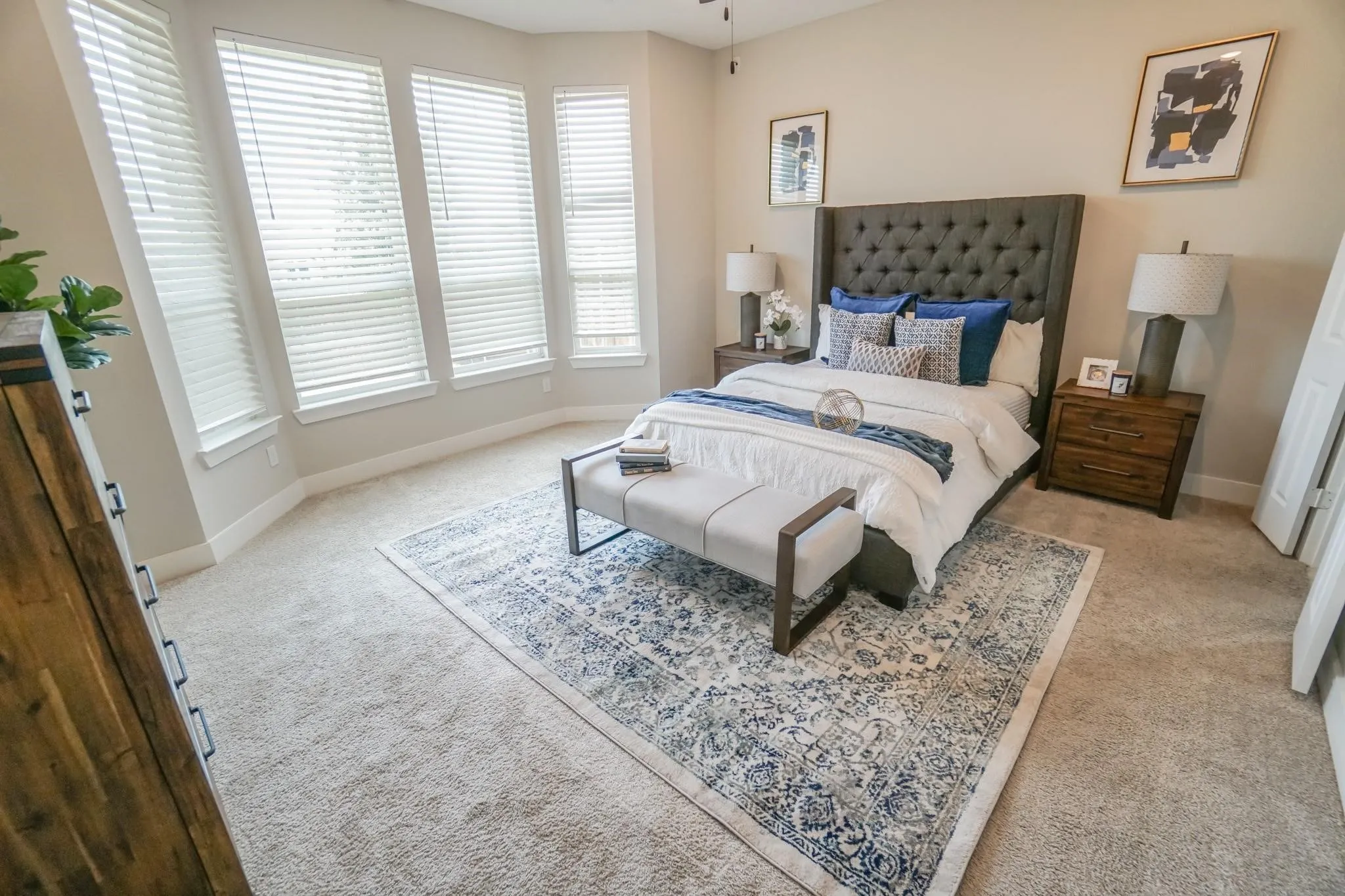 Plush carpeting, multiple windows with blinds, and a built-in ceiling fan