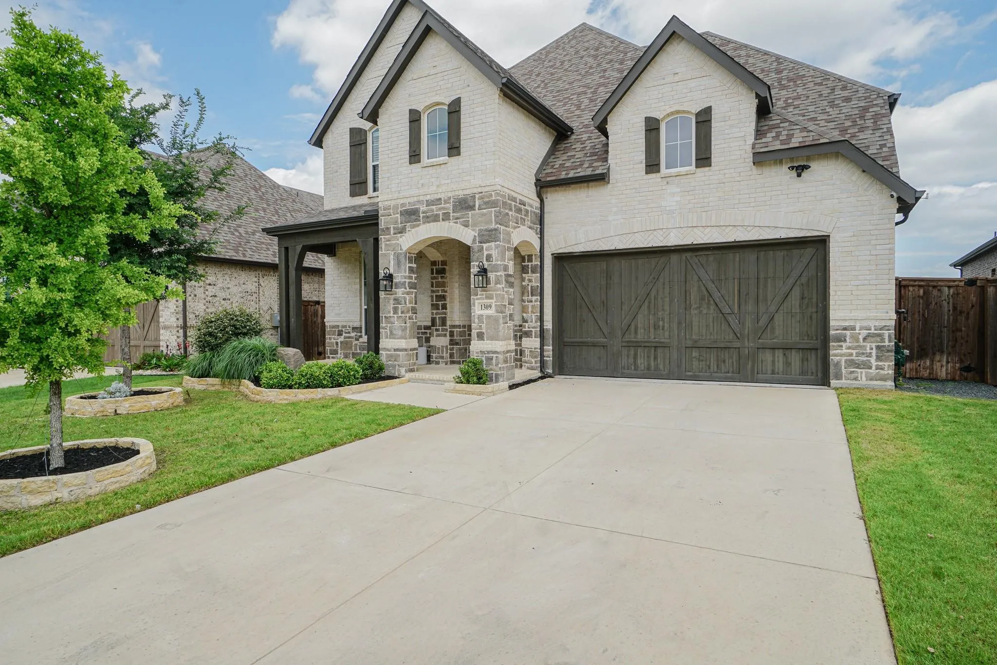Two-story exterior with light-colored brick and stone accents