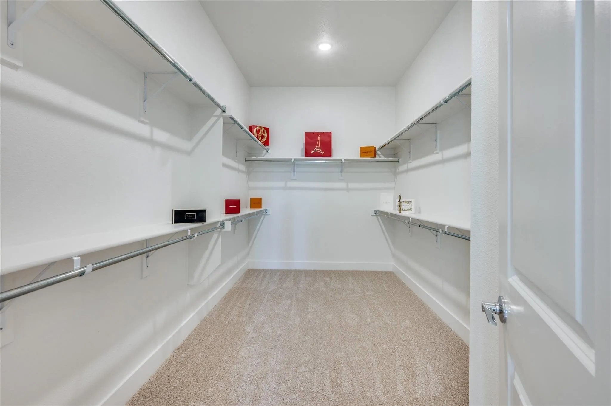 Walk-in closet featuring built-in shelving, hanging rods, recessed lighting, and carpet flooring