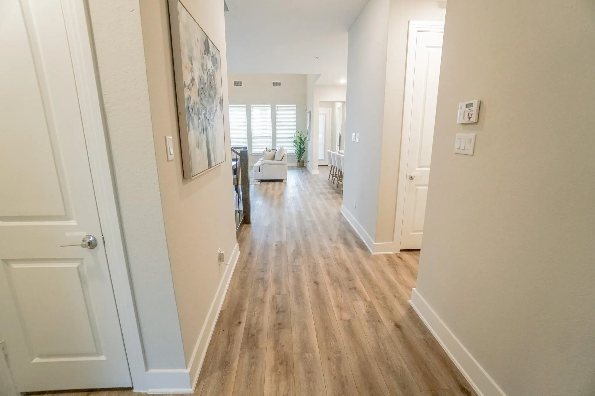 Wood-finish flooring throughout, white interior doors, and neutral wall tones