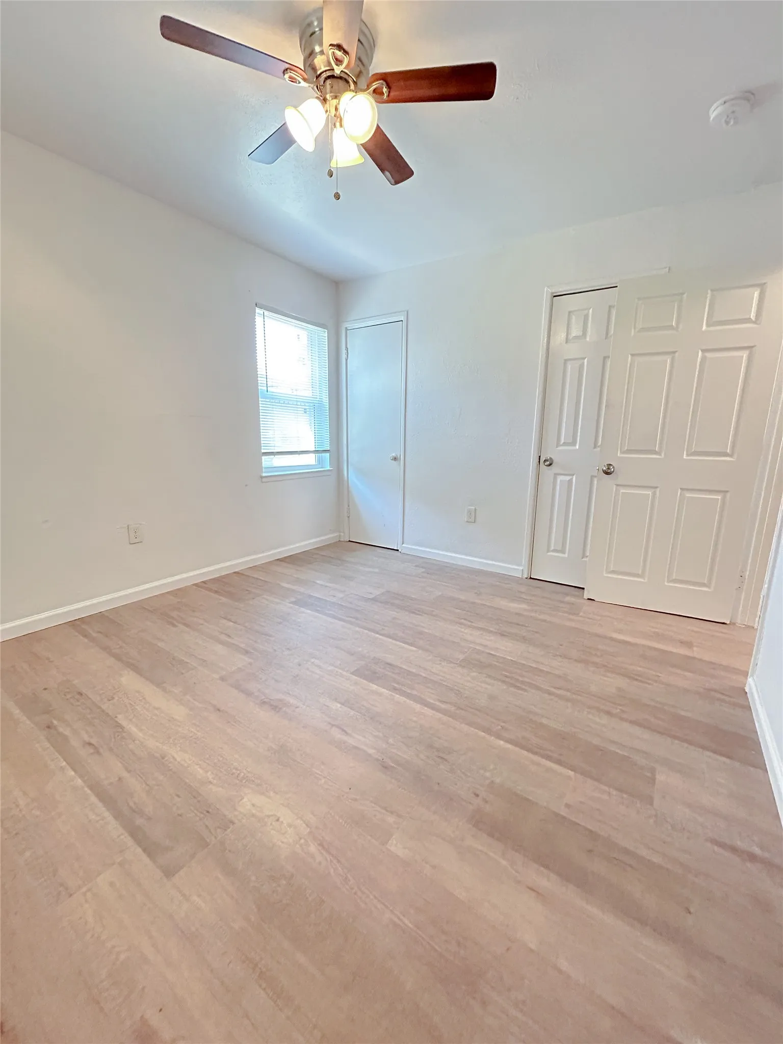 Light wood-finish flooring with white walls
