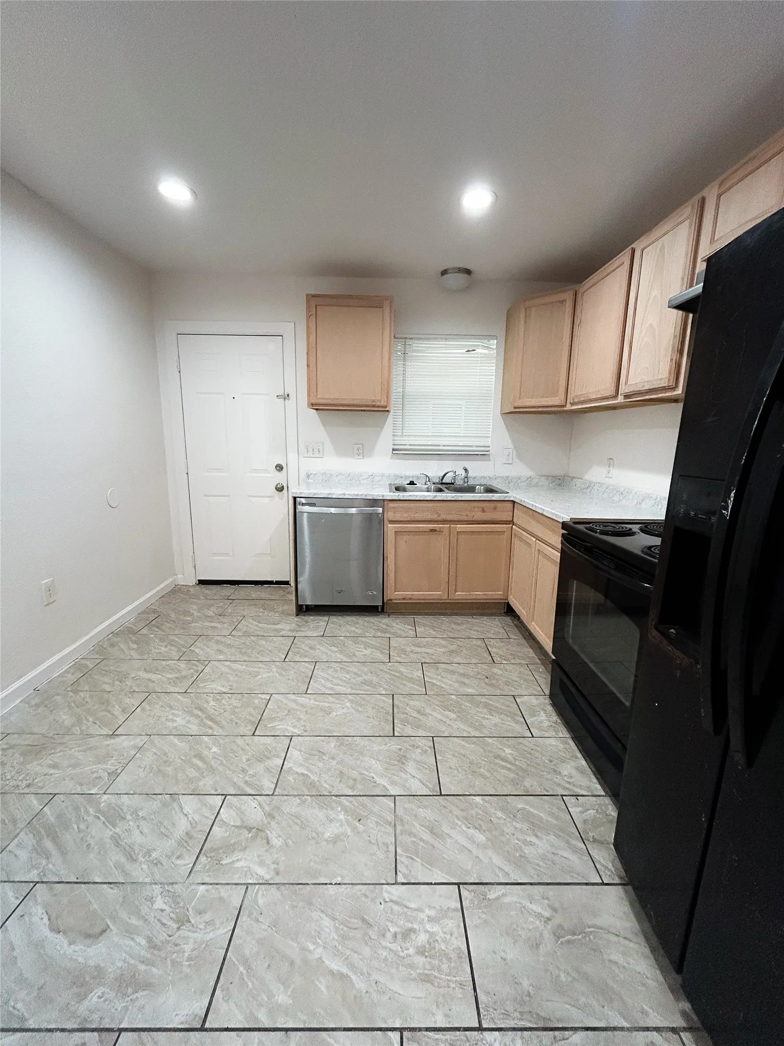 Tile flooring, stainless steel dishwasher, wood-finish cabinetry, built-in cooktop, and recessed lighting