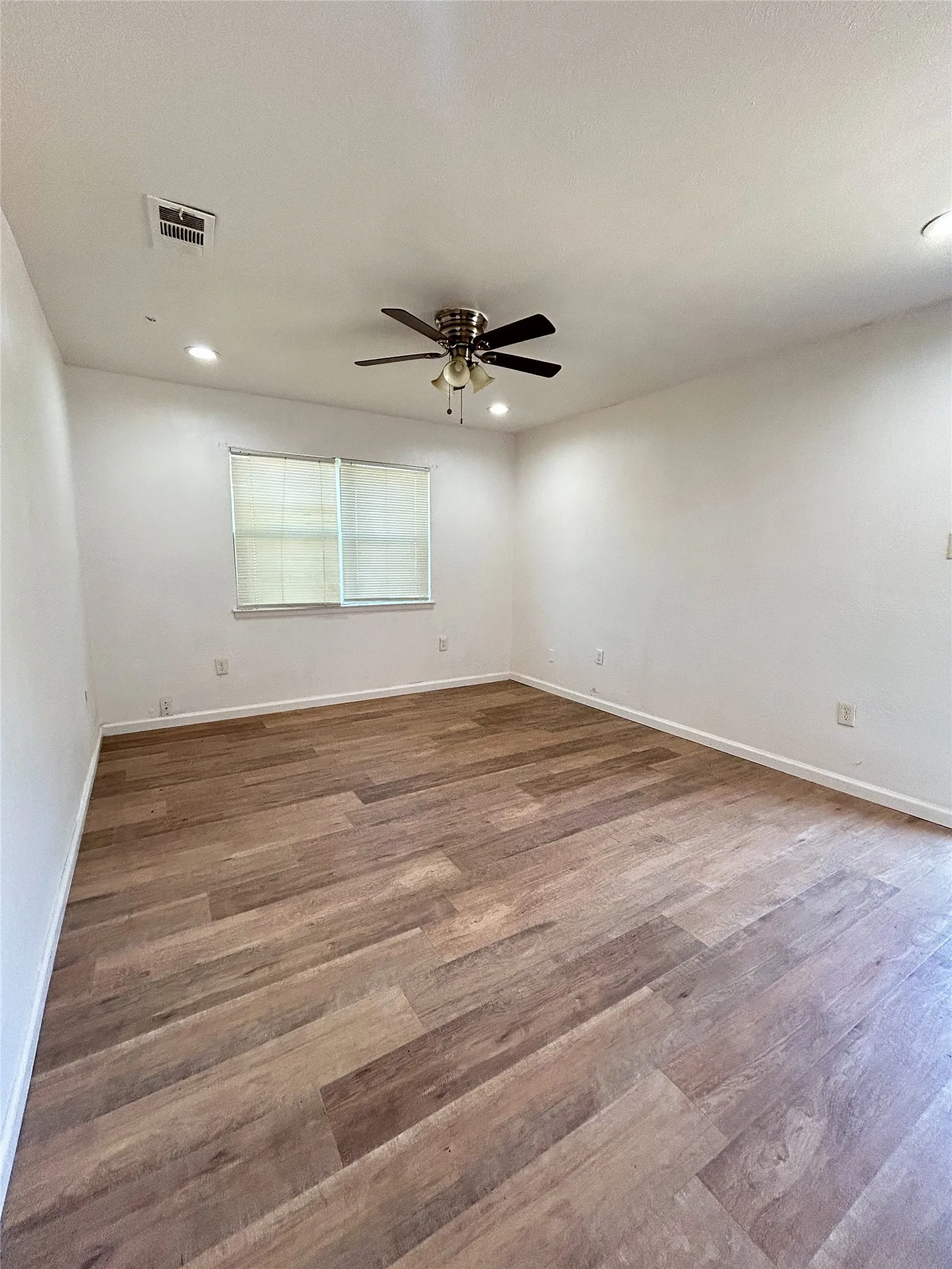 Recessed lighting, wood-finish flooring, ceiling fan, and a window with blinds