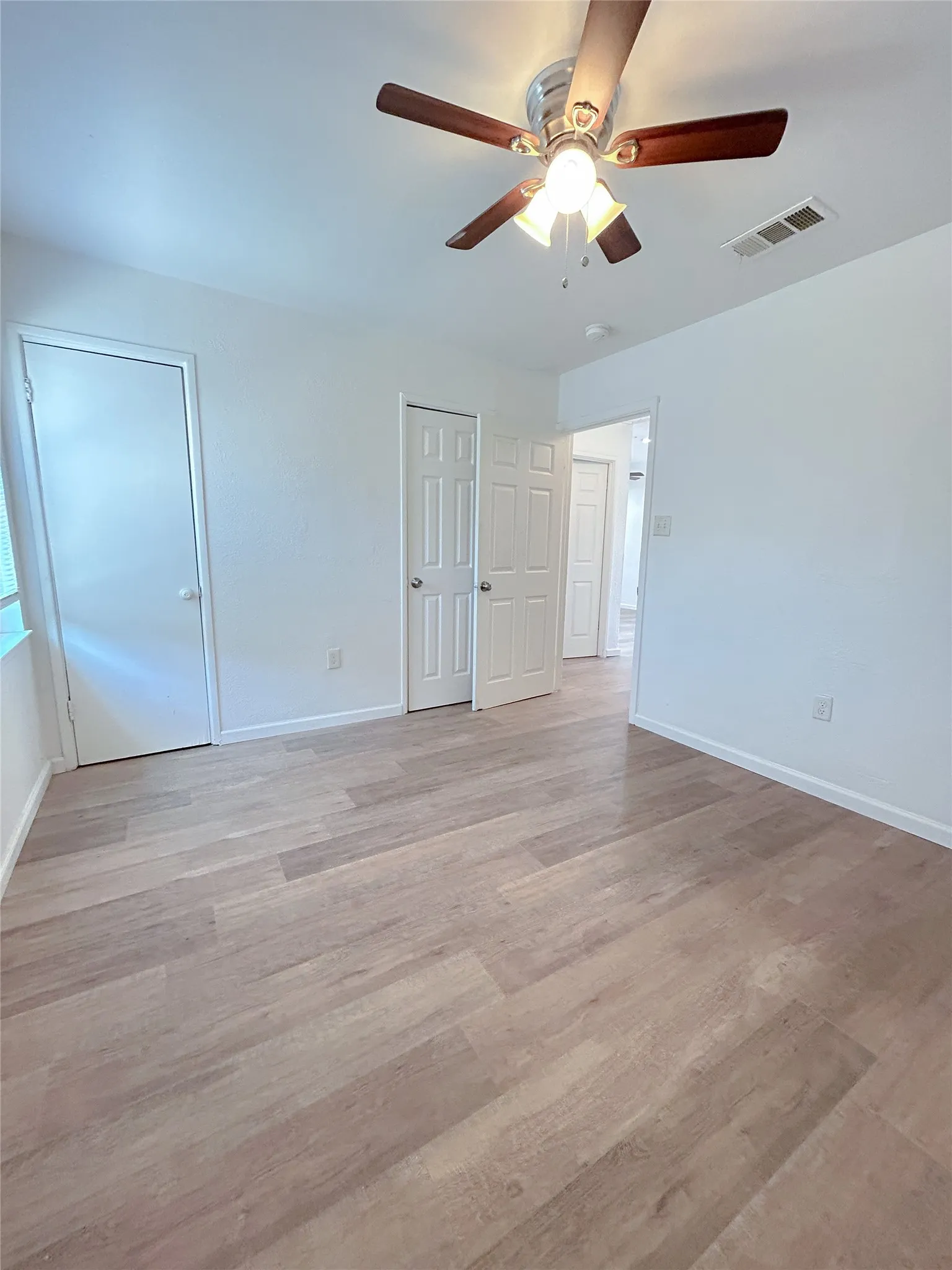 Wood-finish flooring with white walls and trim