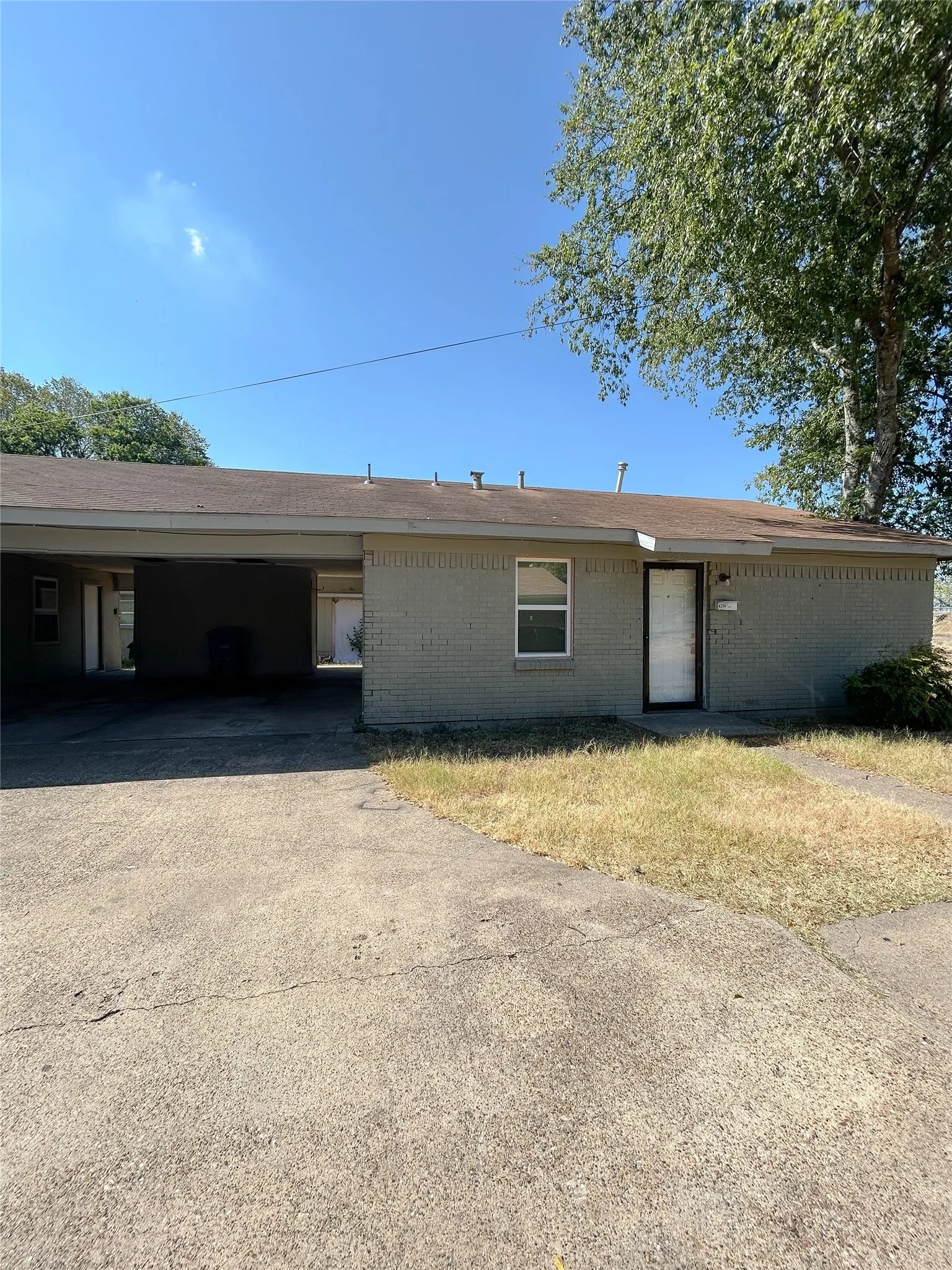 Brick exterior with a covered carport and concrete driveway