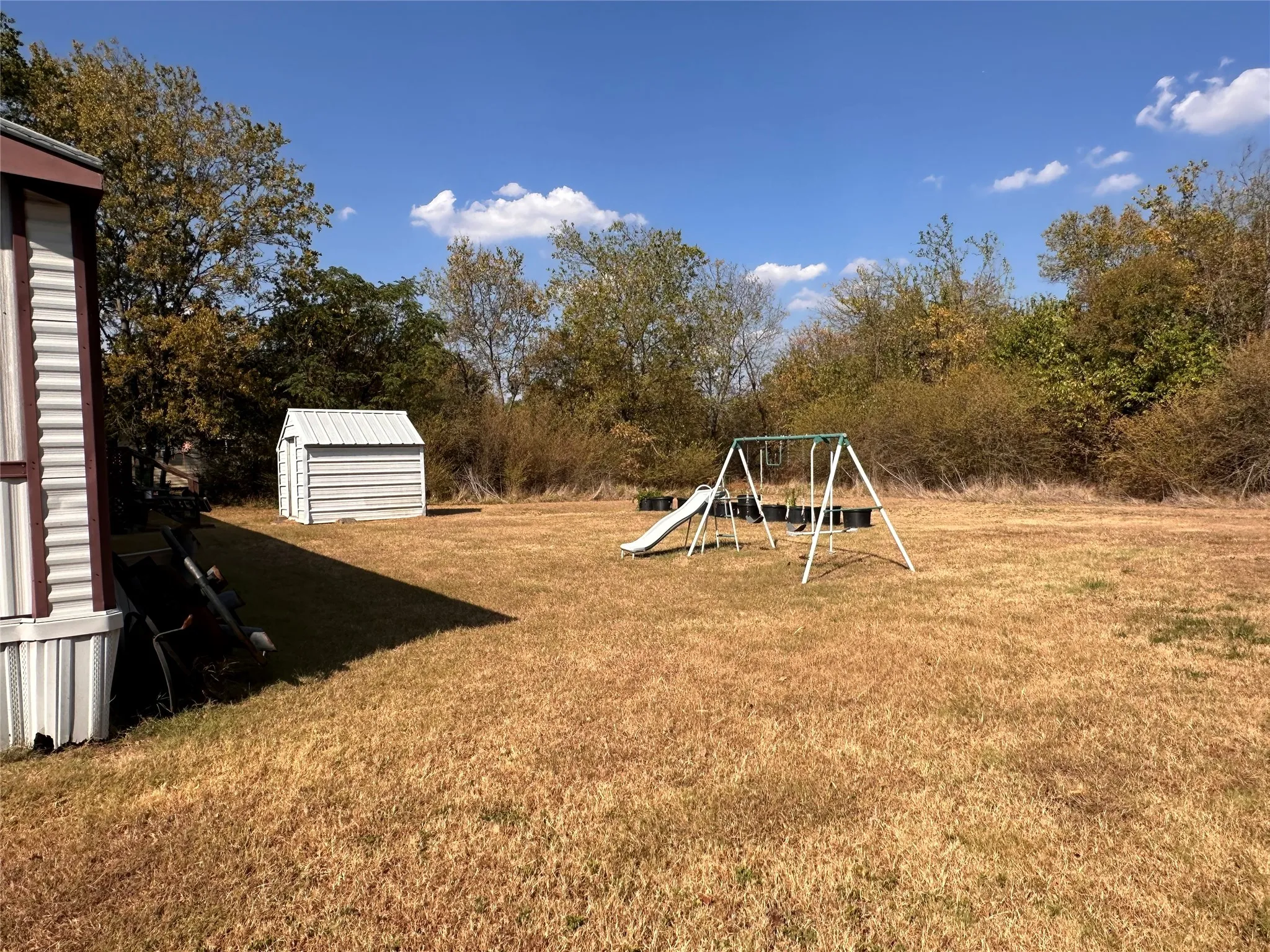 Expansive back yard featuring a storage shed and mature perimeter trees
