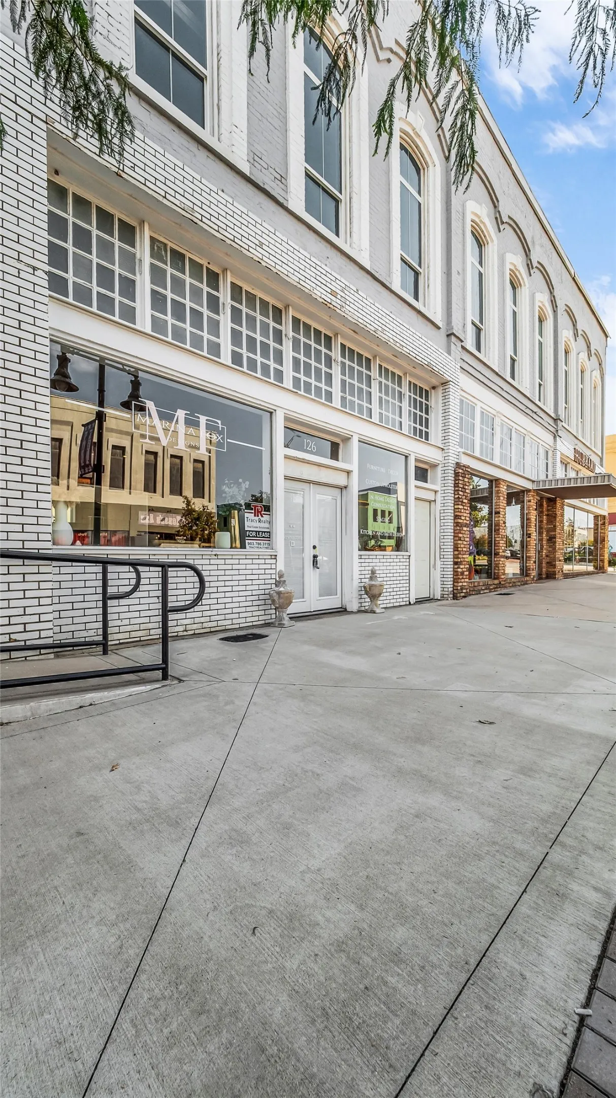 Commercial building featuring a brick facade, arched windows, and ground-level retail space