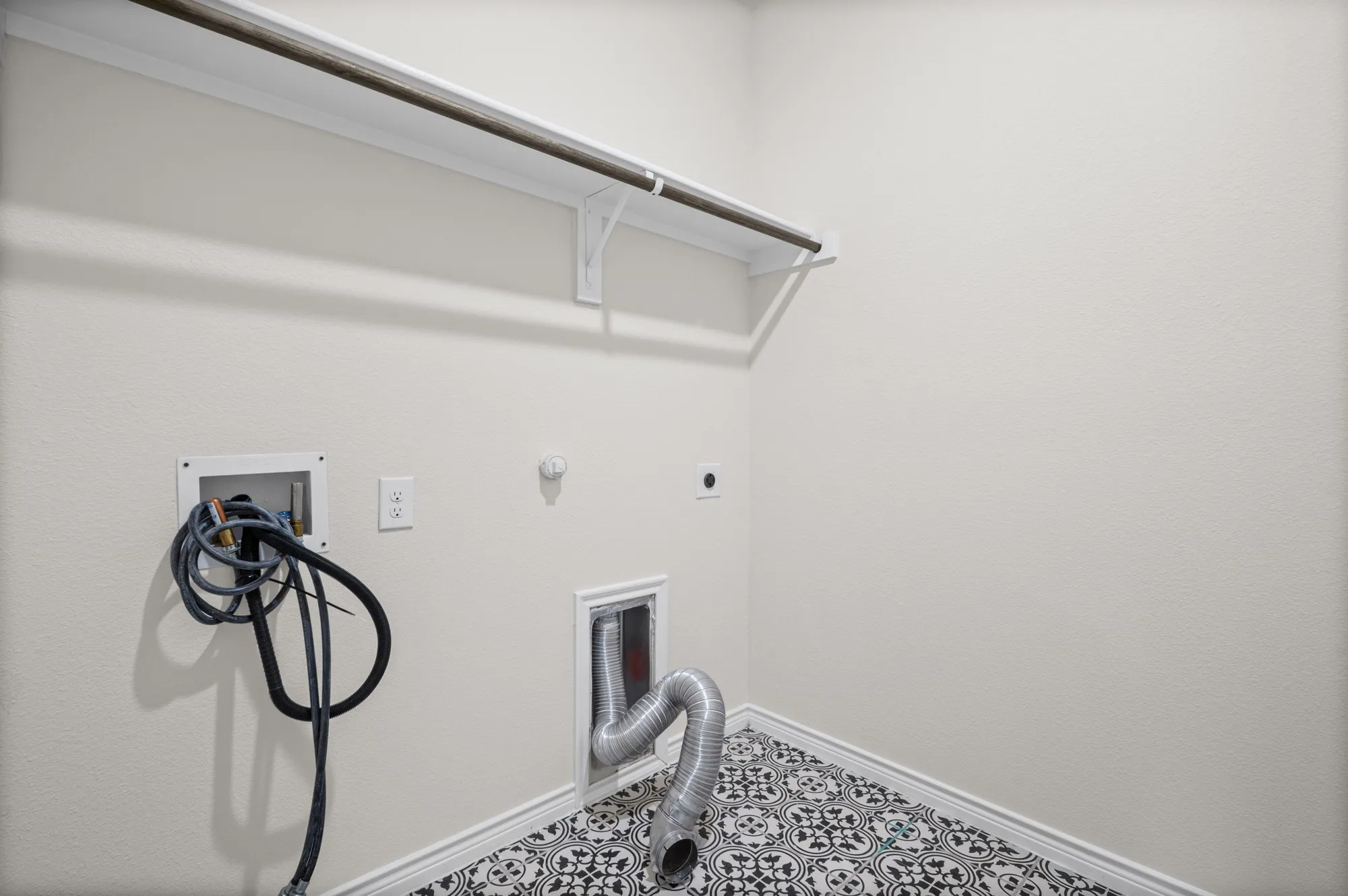 Laundry area featuring a utility hookup, dryer vent, and patterned floor tile
