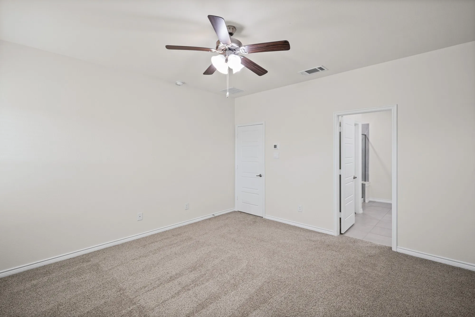 Neutral-toned carpeting, ceiling fan with integrated lighting, white interior doors, and pale wall finishes